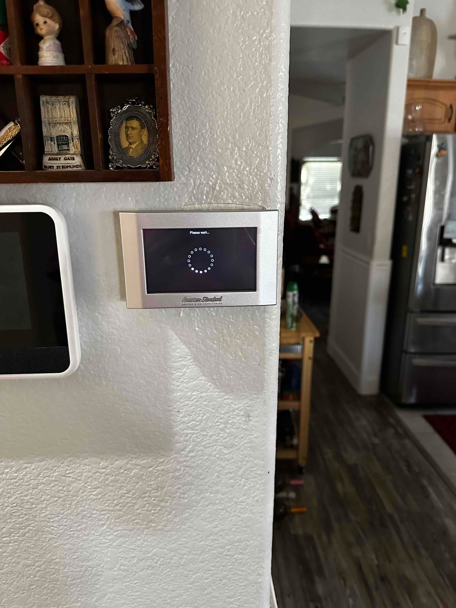 Wall-mounted thermostat displays a startup message, indicating system setup or reboot during a new installation.