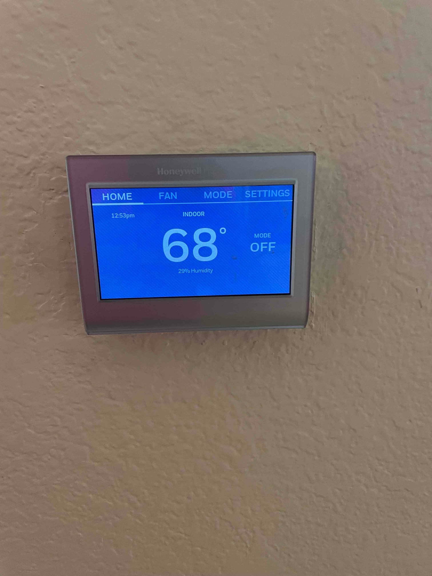Wall-mounted thermostat screen shows indoor temperature 68° and 29% humidity with system mode off.