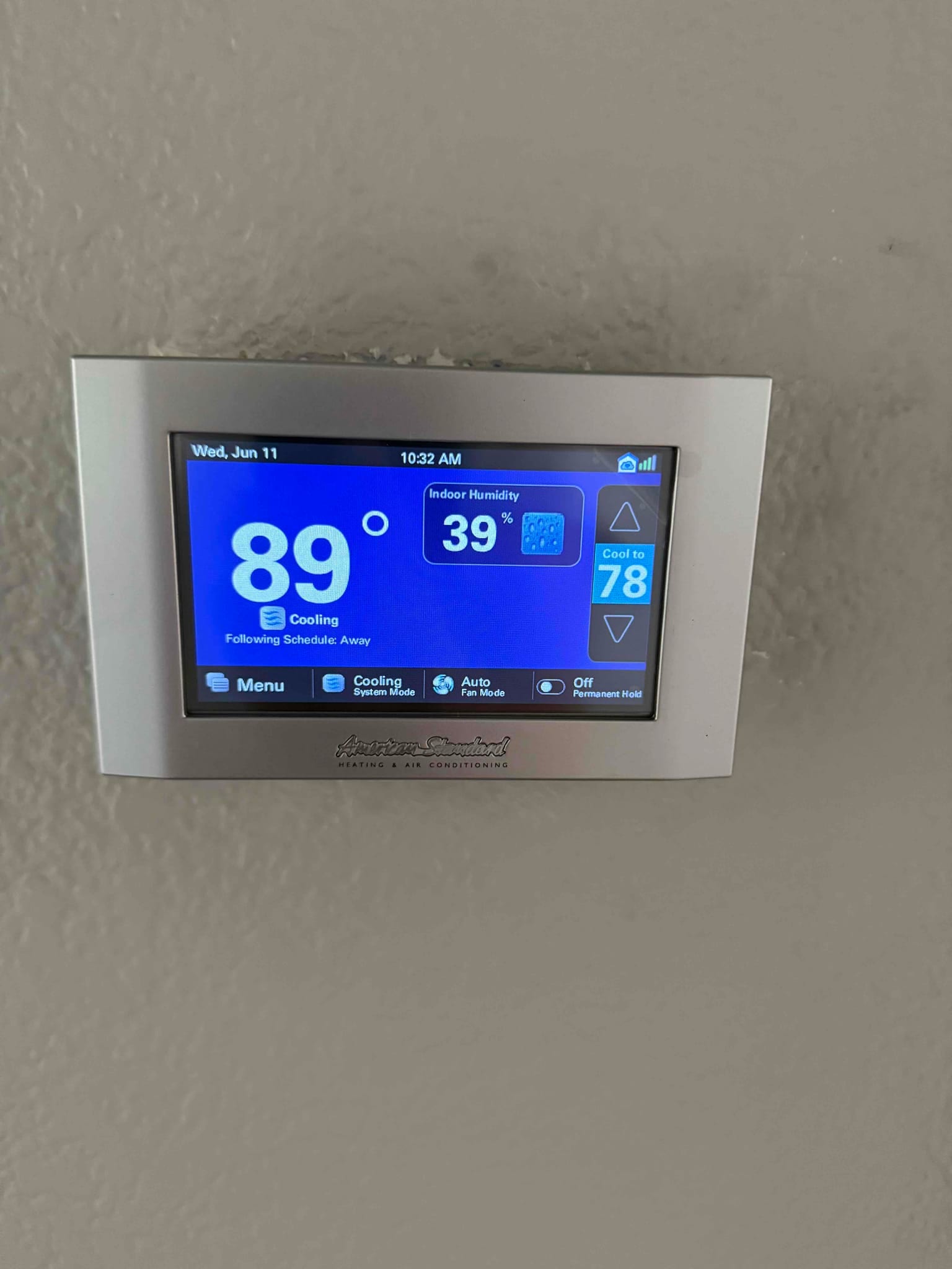 Wall-mounted touchscreen thermostat displays 89 degrees with cooling mode active and indoor humidity at 39 percent.