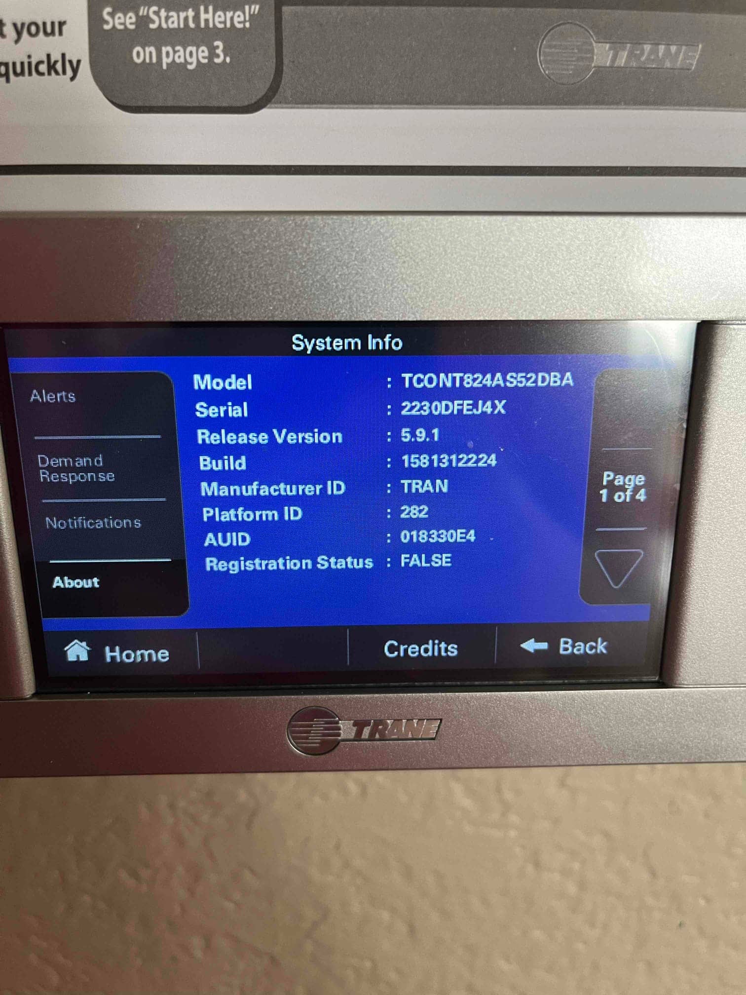 Wall-mounted touchscreen thermostat displays system information on the screen after installation.