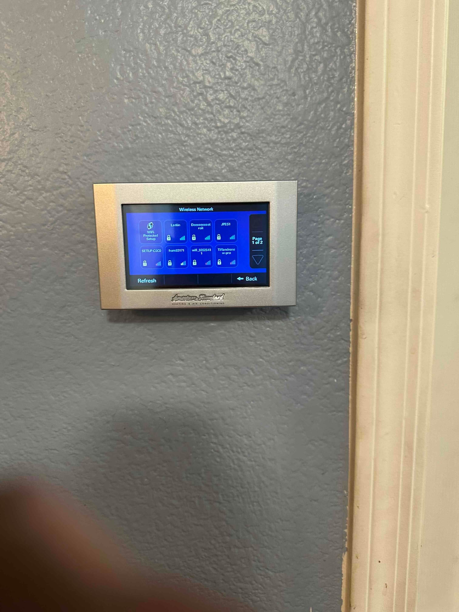 Wall-mounted touchscreen thermostat displays wireless network setup screen during commissioning of the new HVAC control system.