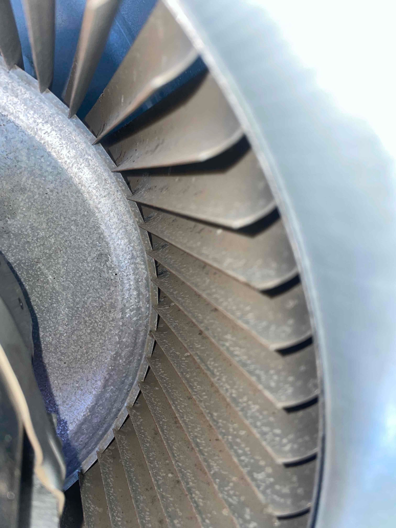 Close-up of a blower wheel with visible dust buildup on the metal blades.