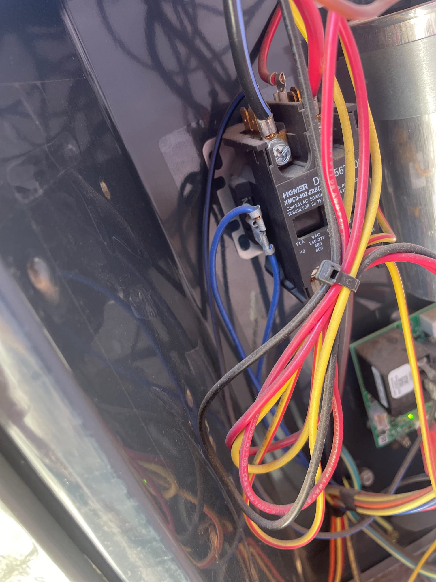 Contactor with connected wiring inside outdoor condenser compartment next to dual-run capacitor and control board.