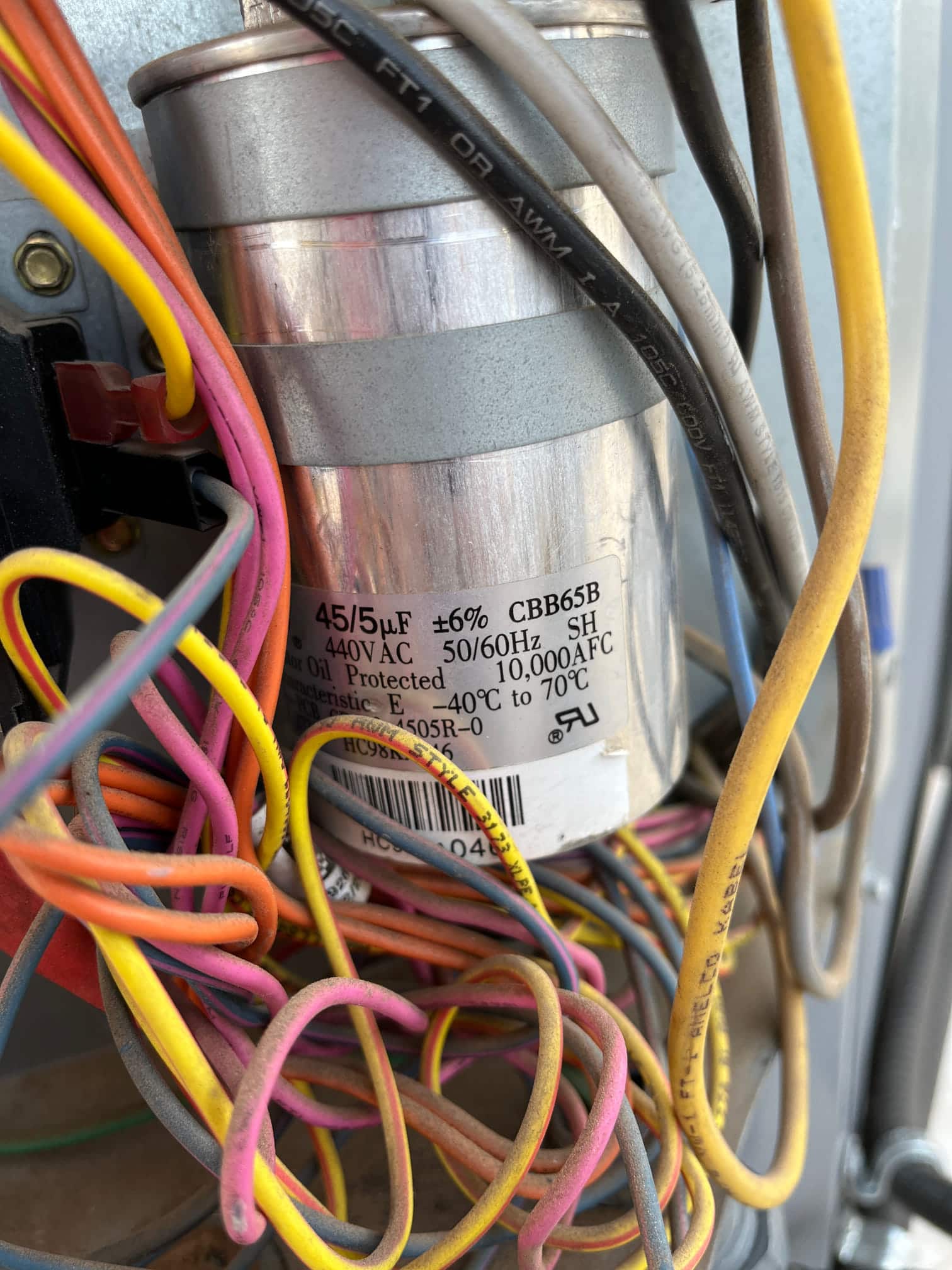 Dual-run capacitor labeled 45/5 μF ±6% 440VAC, with multiple colored wires connected to its terminals.