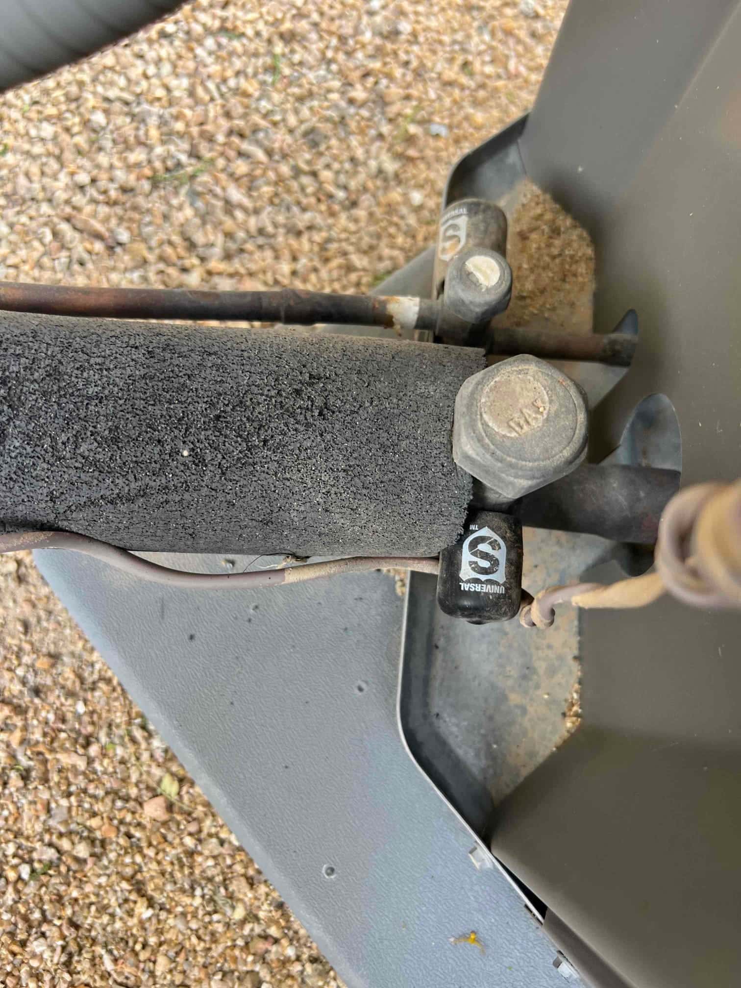 Outdoor condenser service valves and refrigerant lines, with black insulation on the suction line and protective caps installed.