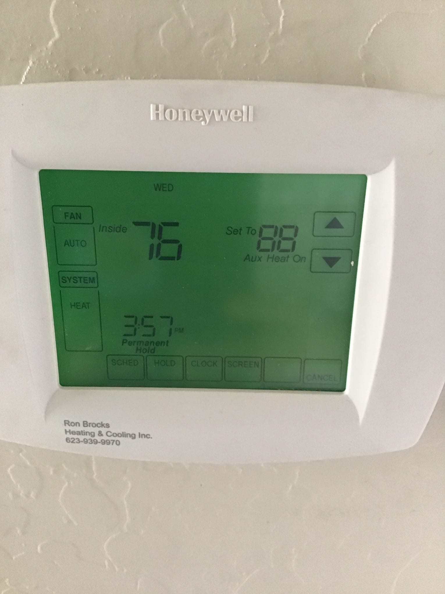 Programmable thermostat display showing inside 76°F, set to 88°F, heat mode with auxiliary heat on.