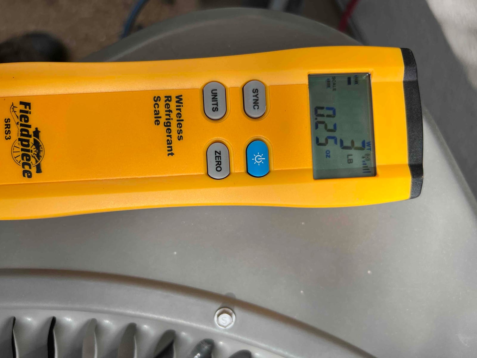 Refrigerant scale photographed during the service visit; no numerical reading is transcribed.