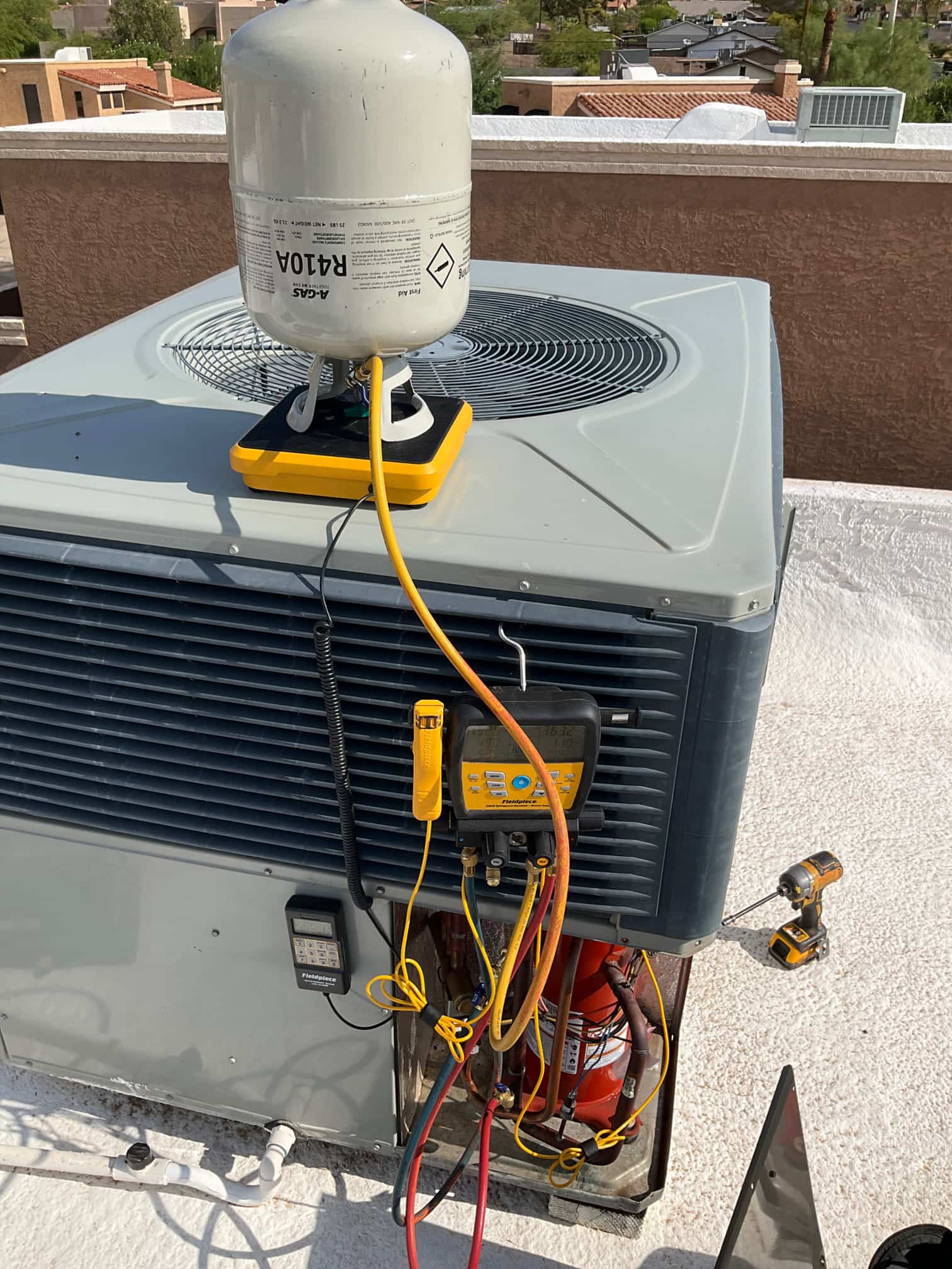 Refrigerant scale photographed during the service visit; no numerical reading is transcribed.