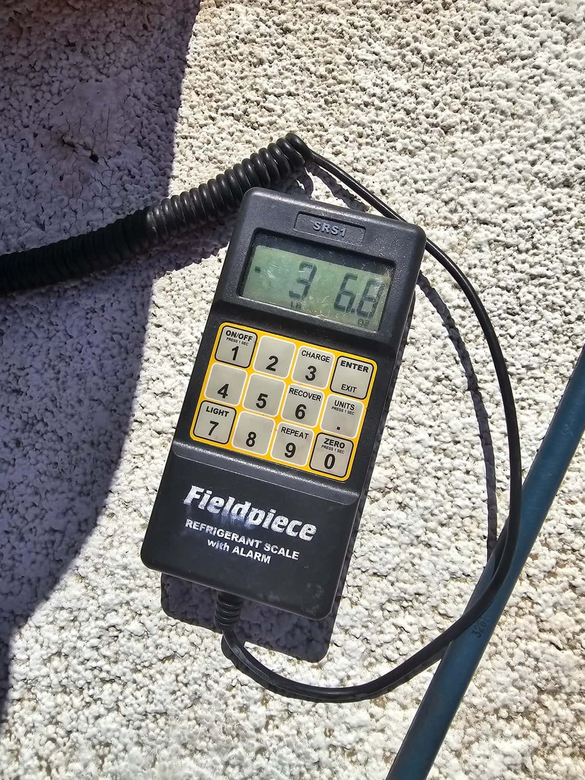 Refrigerant scale photographed during the service visit; no numerical reading is transcribed.