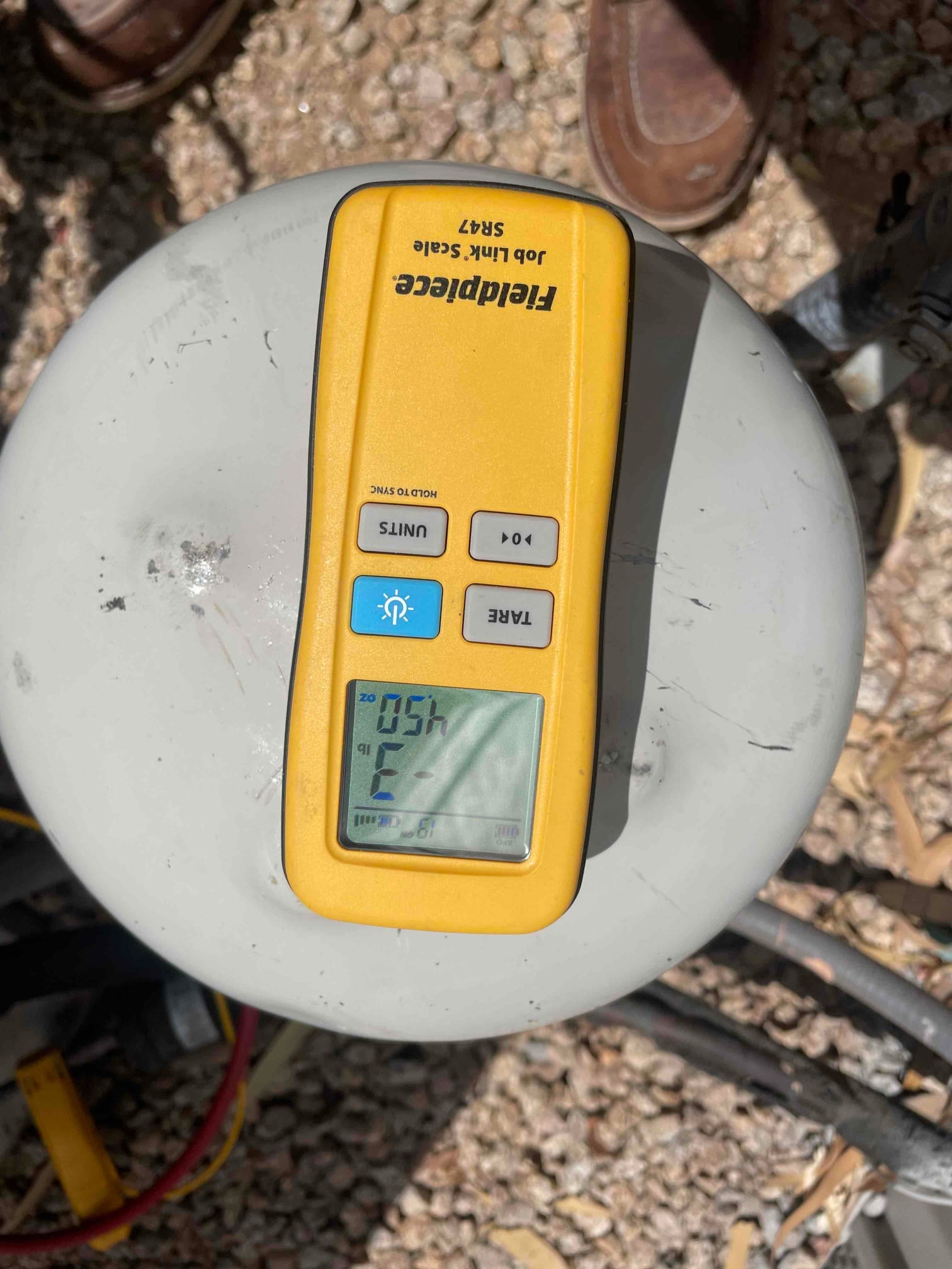 Refrigerant scale photographed during the service visit; no numerical reading is transcribed.