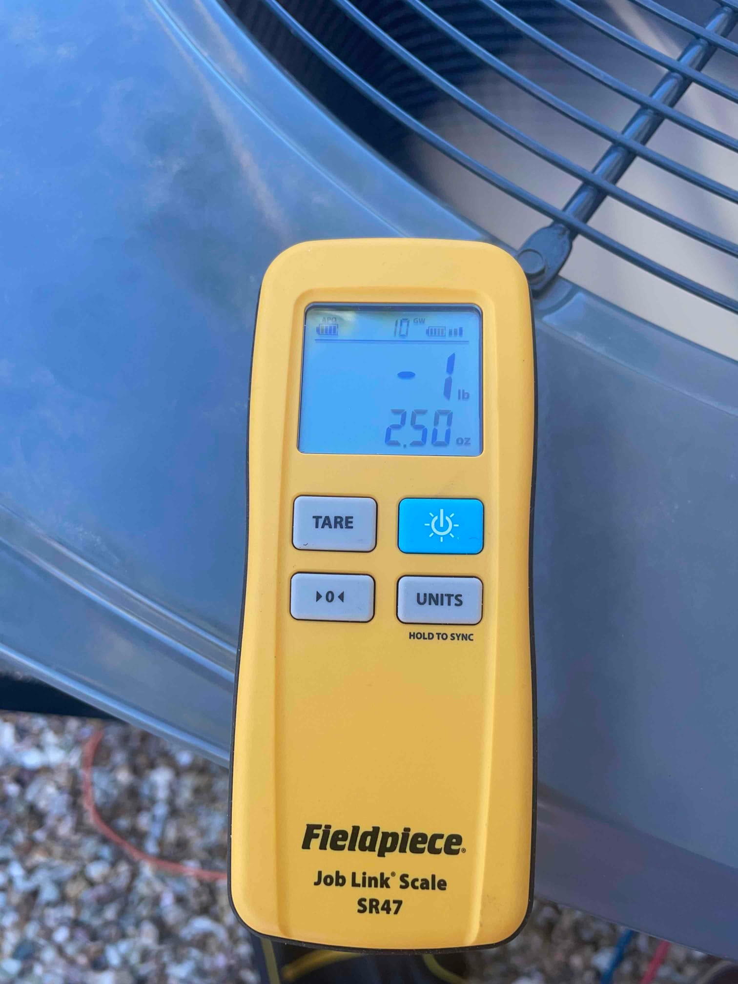 Refrigerant scale photographed during the service visit; no numerical reading is transcribed.
