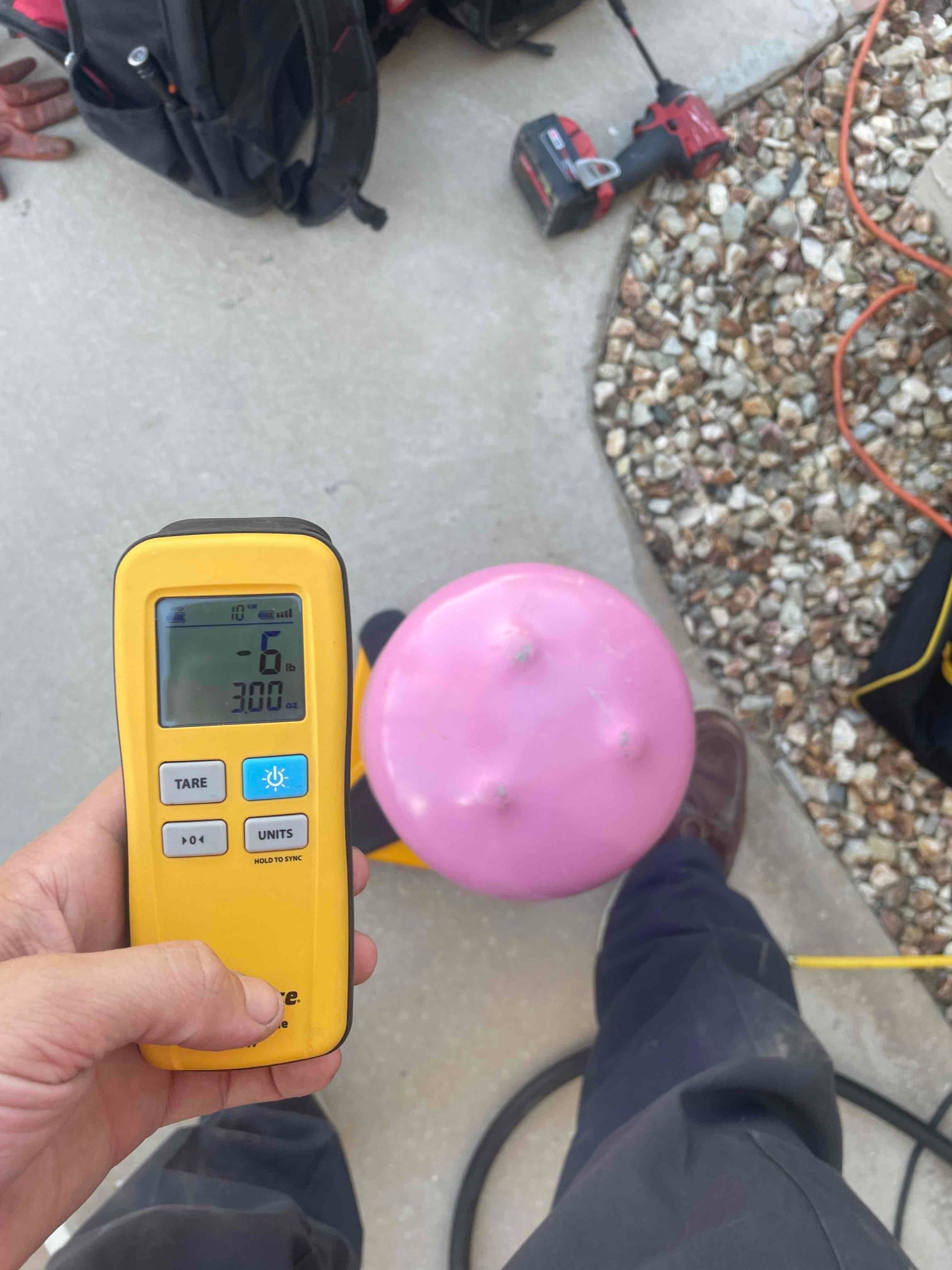 Refrigerant scale photographed during the service visit; no numerical reading is transcribed.