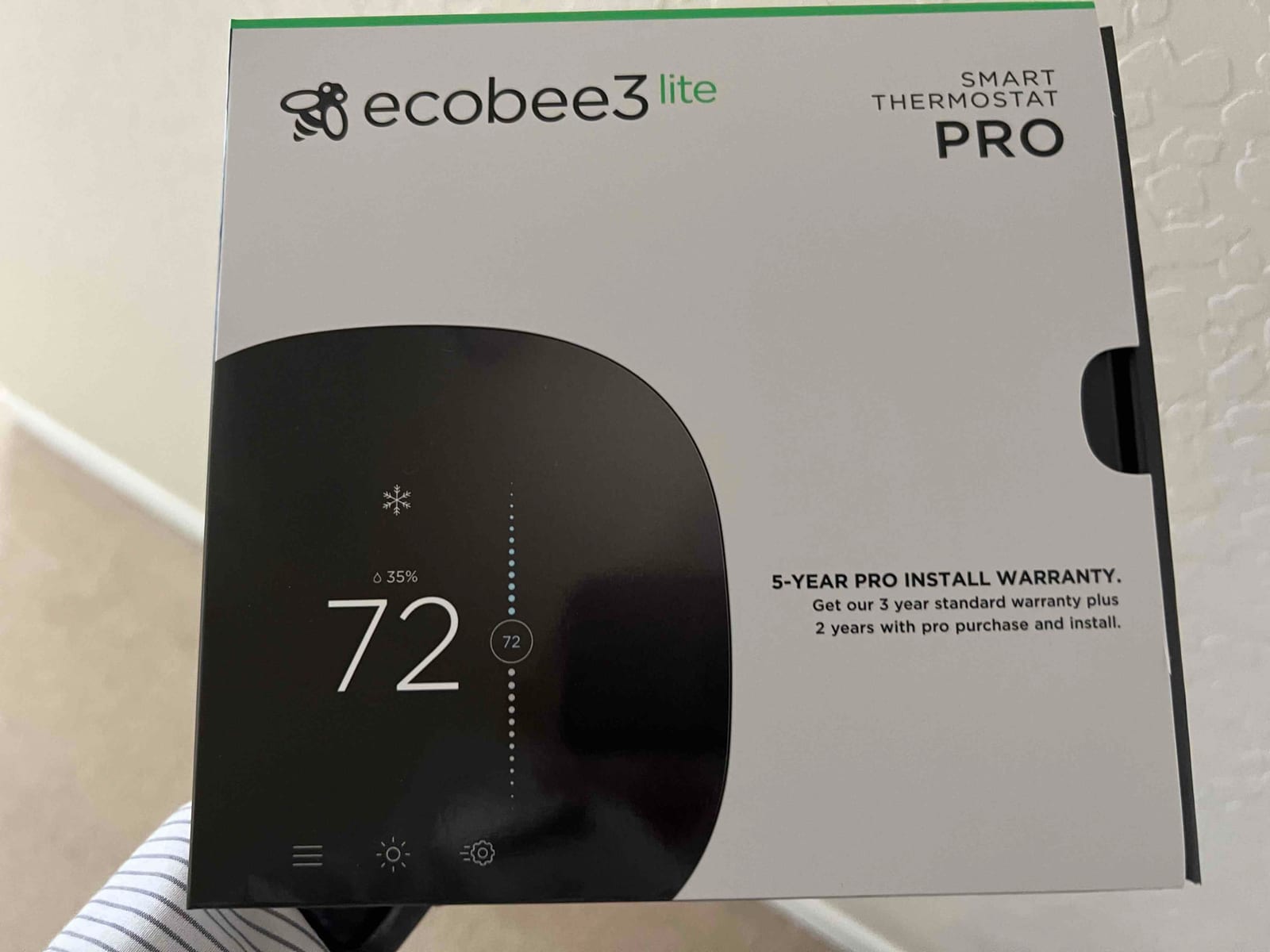 Retail box for a smart thermostat, showing the thermostat screen graphic and warranty text.