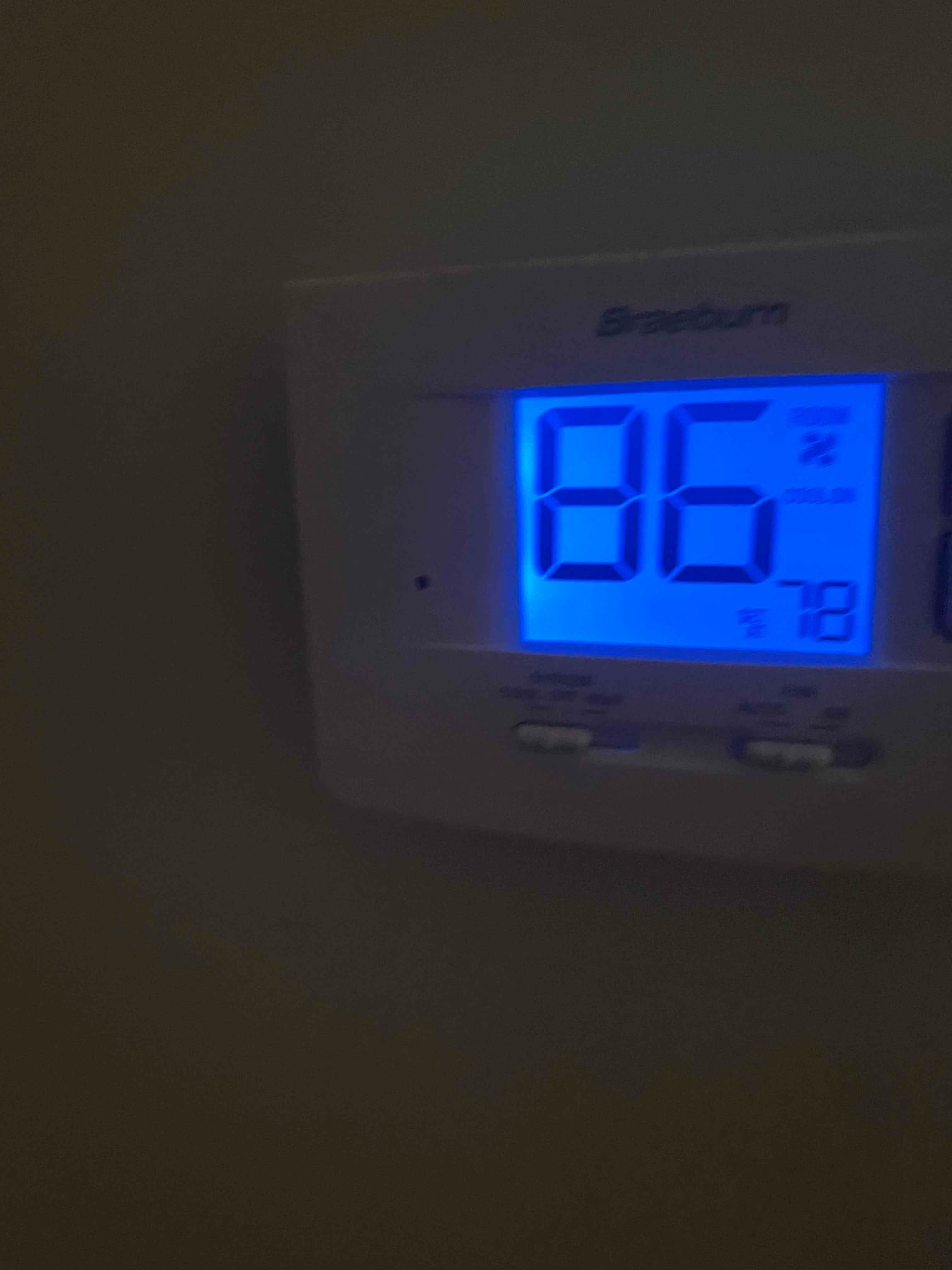 Wall-mounted digital thermostat with blue backlight showing indoor temperature 86 and setpoint 78.