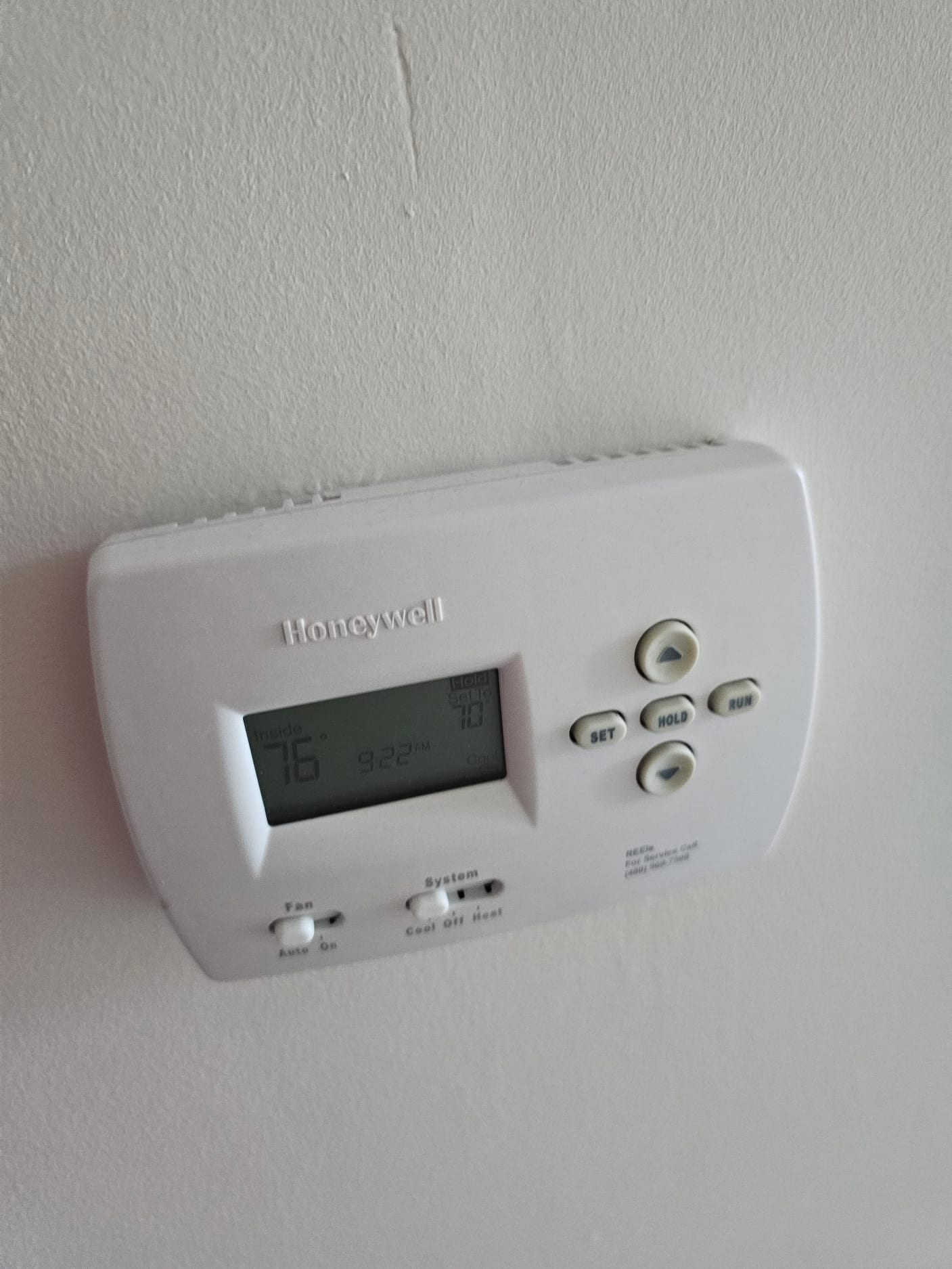Wall-mounted digital thermostat showing inside temperature 76°F and setpoint 70°F with system in cool.