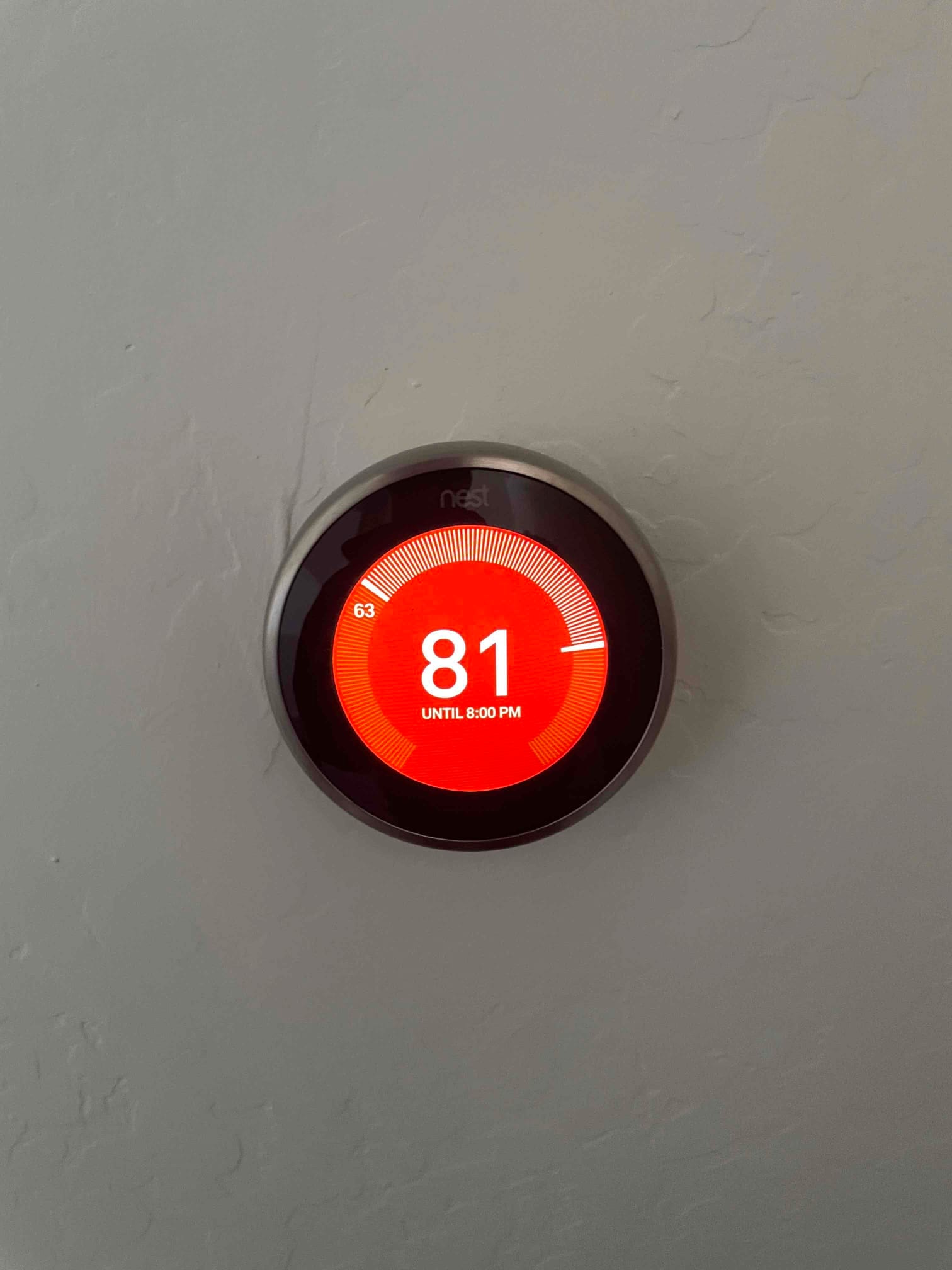 Wall-mounted smart thermostat display shows set temperature 81 with a hold until 8:00 PM.