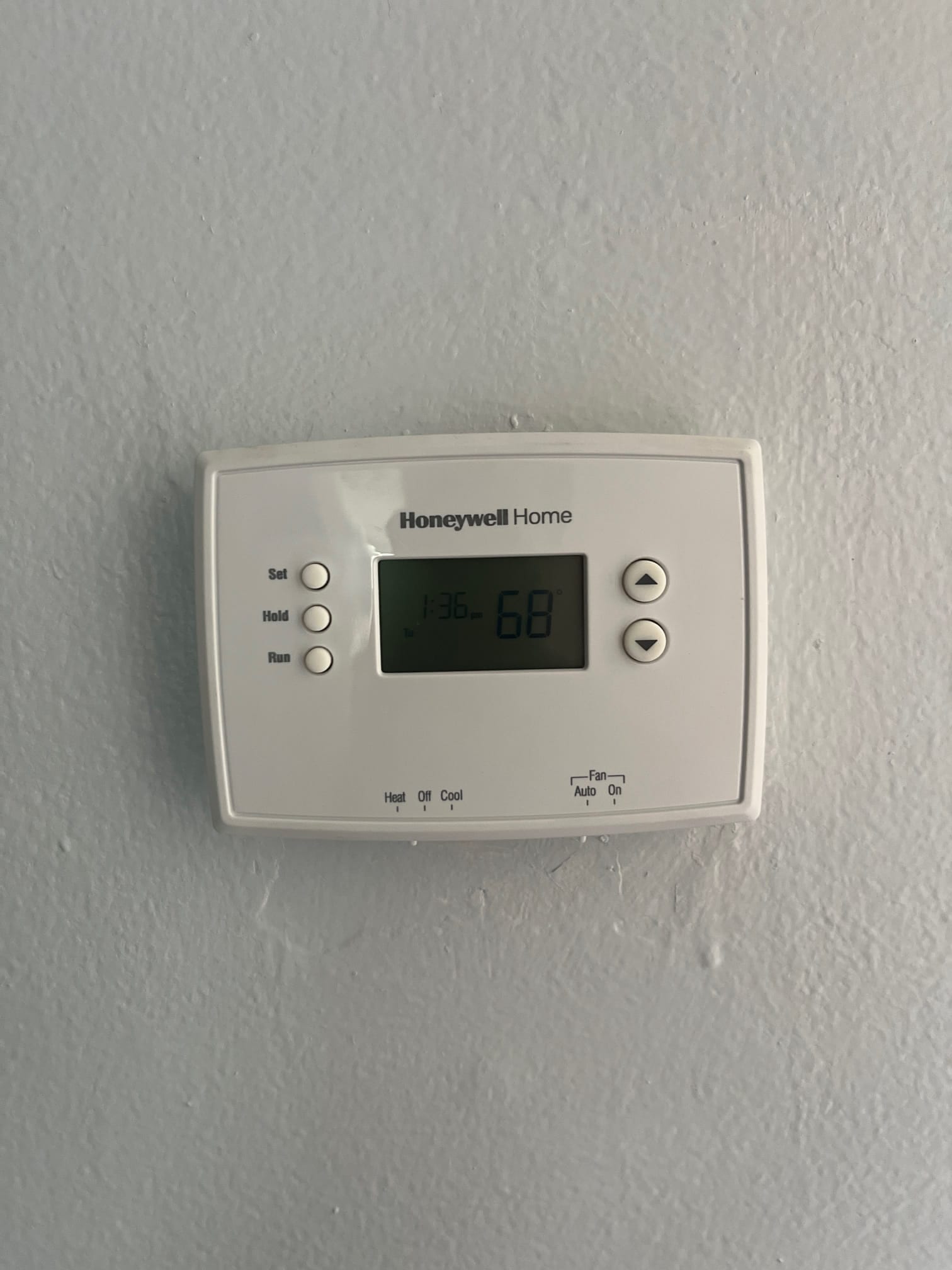 Wall-mounted thermostat display shows 68° and 1:36 pm, with arrow buttons and heat/cool and fan mode switches.