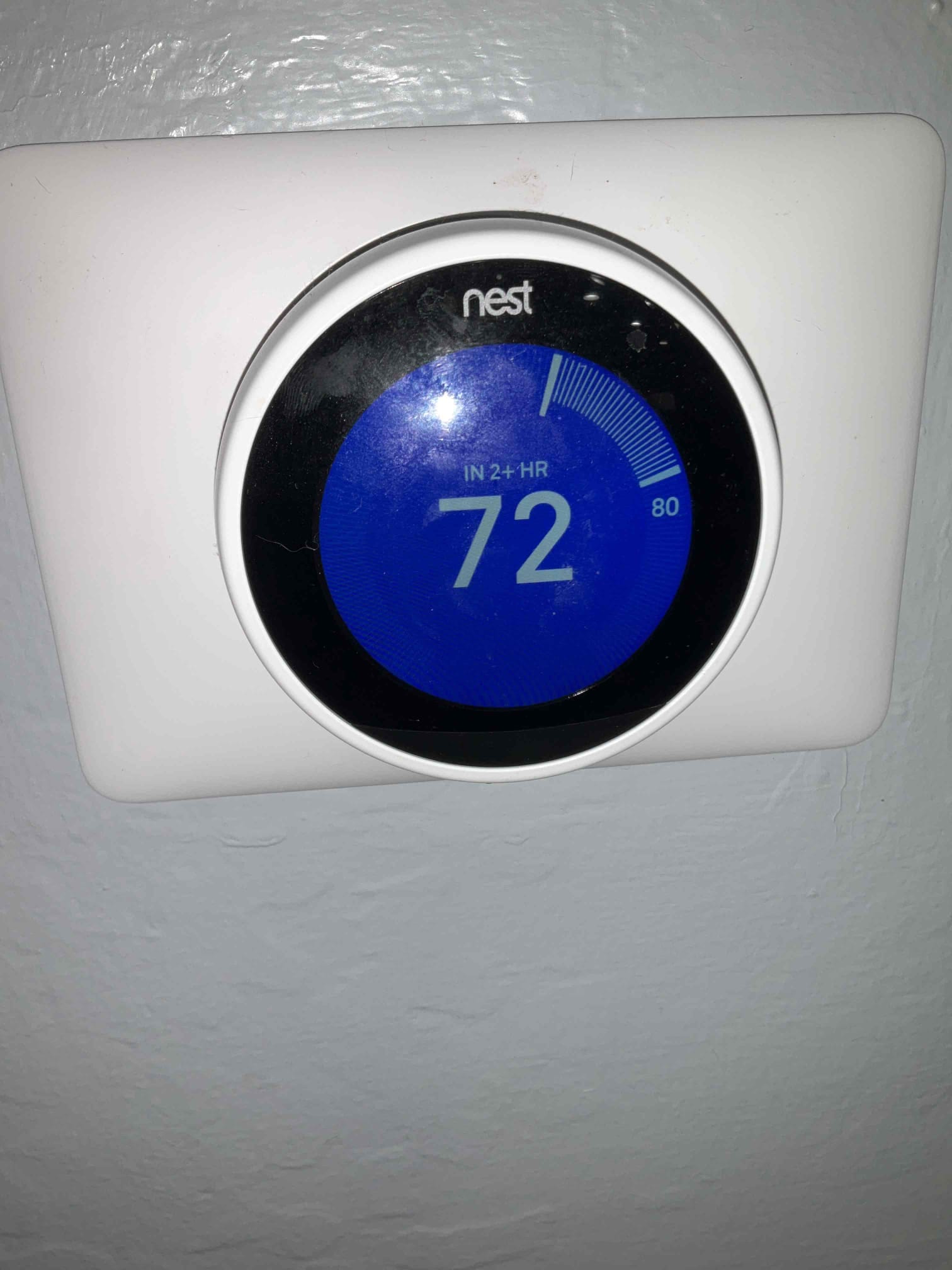 Wall-mounted thermostat display shows 72 degrees on a blue screen with a time estimate indicator.