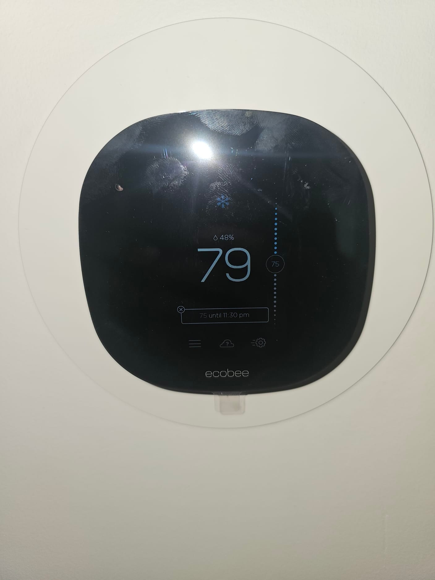Wall-mounted thermostat display shows 79 indoor temperature, 48% humidity, cooling mode, set to 75 until 11:30 pm.