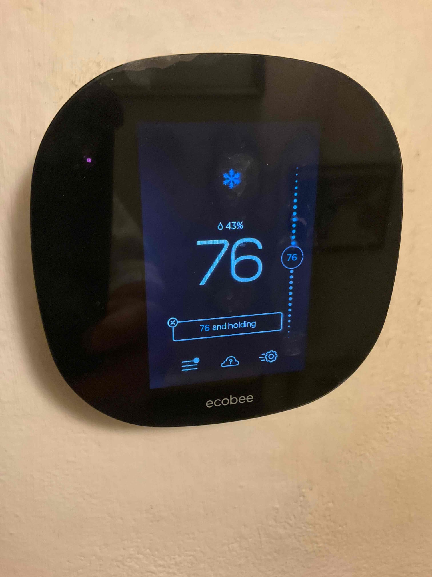 Wall-mounted thermostat display shows cooling mode with indoor temperature at 76 and 43% humidity.
