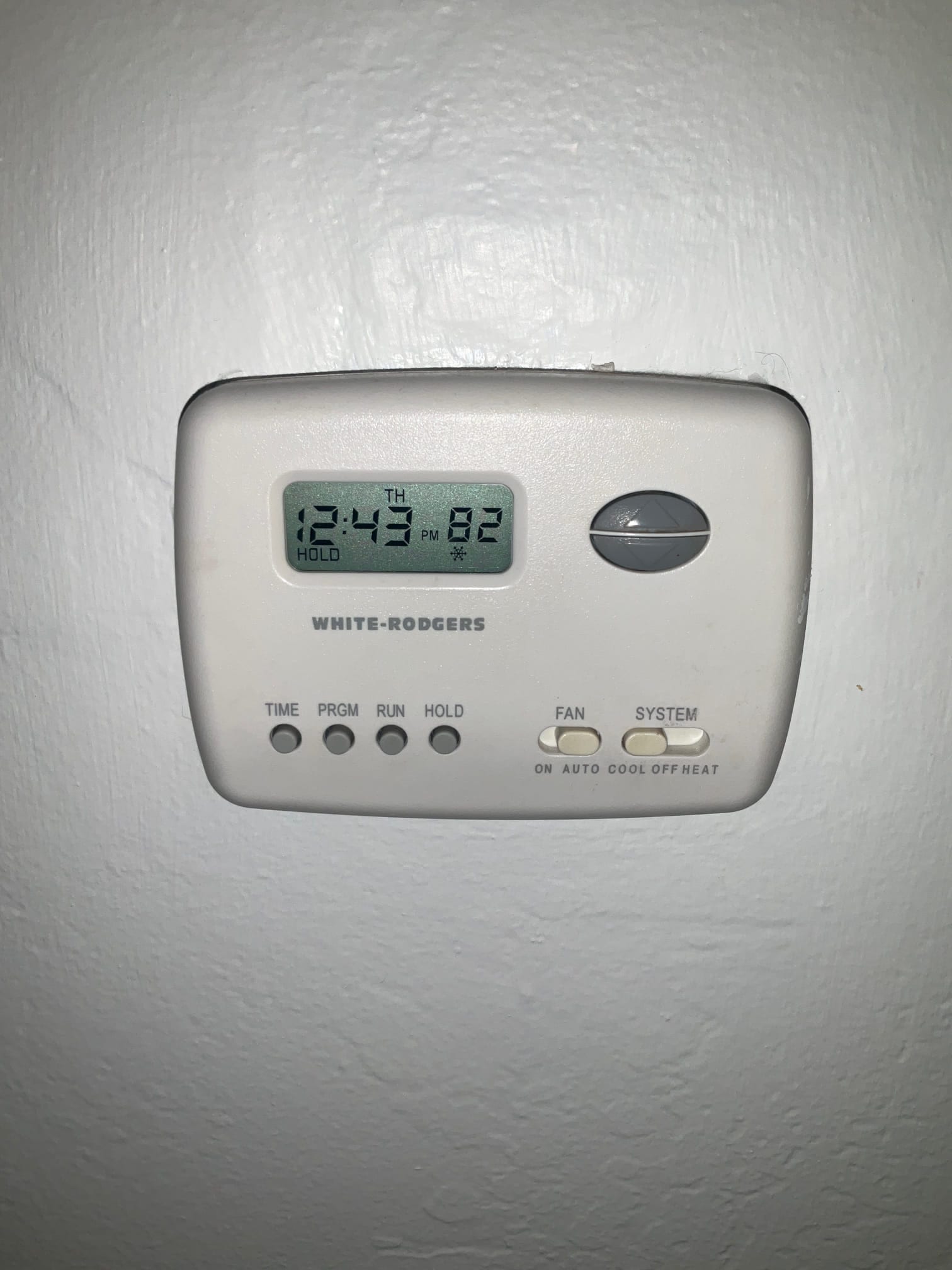 Wall-mounted thermostat displays 82°F at 12:43 PM, system set to COOL, fan on AUTO.