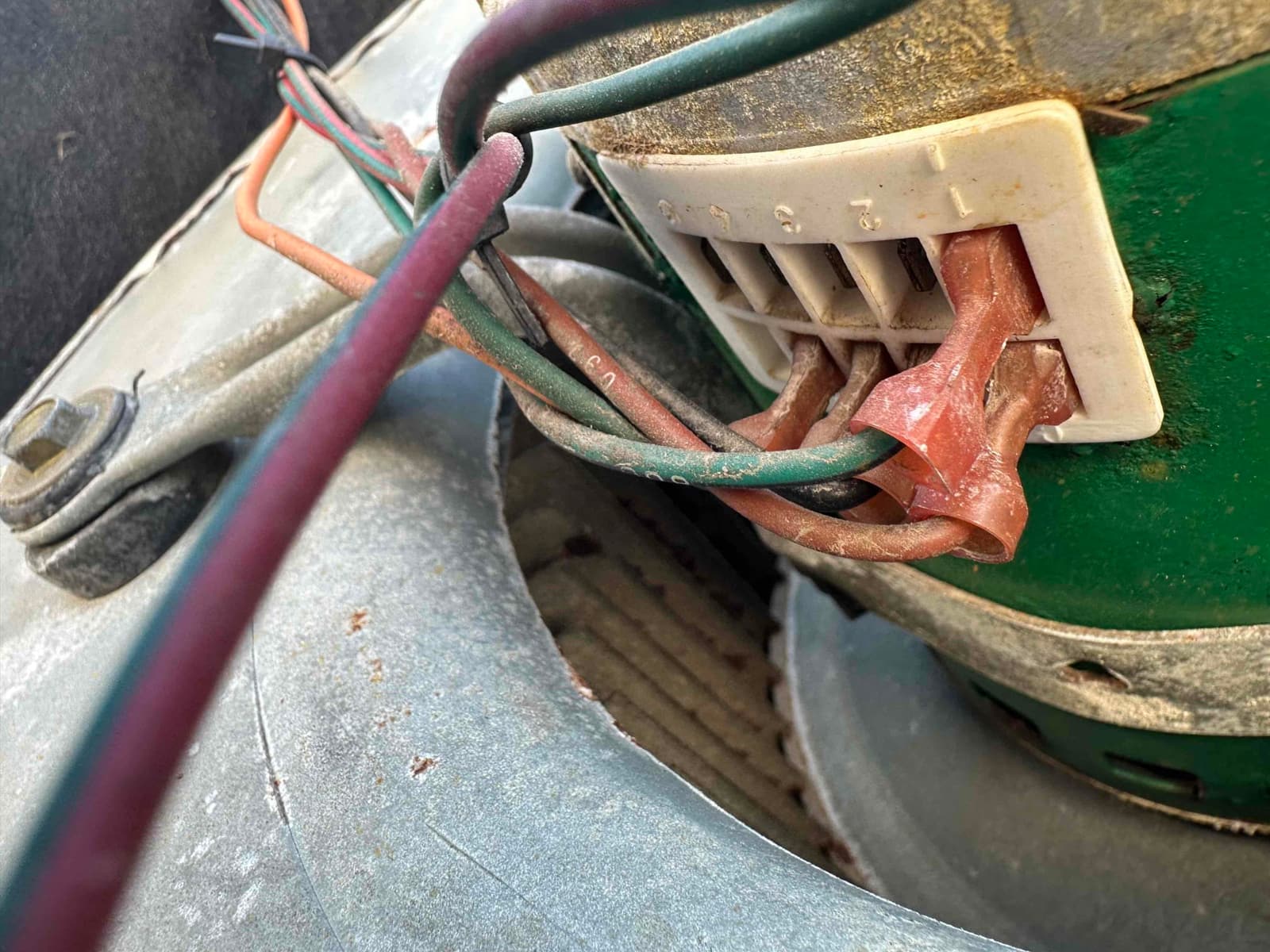 ECM blower motor wiring connector with multiple colored leads inserted into labeled terminals on the motor housing.