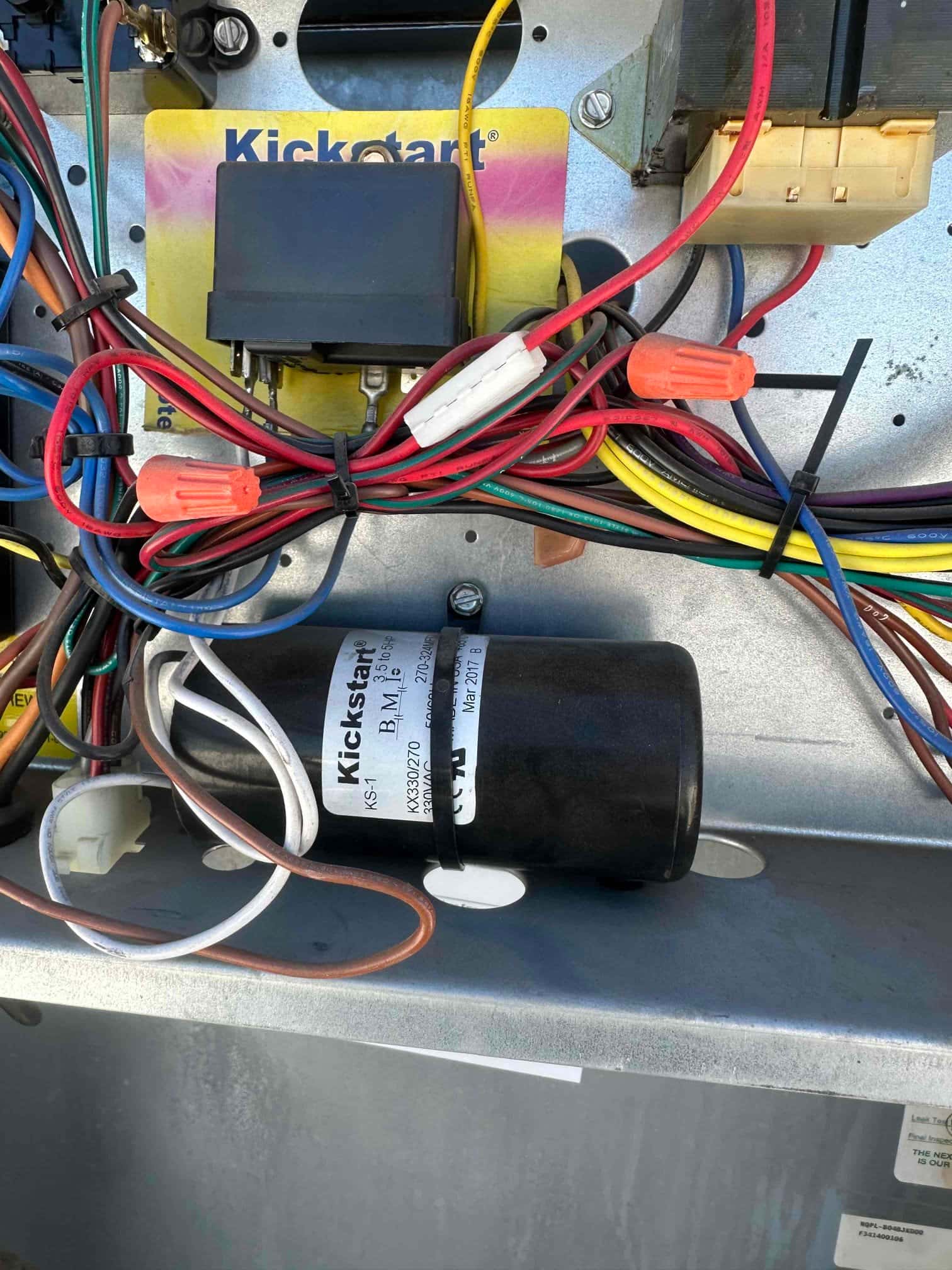 Kickstart hard start capacitor kit installed in control compartment, labeled 155–188 μF, with multiple connected wires and wire nuts.