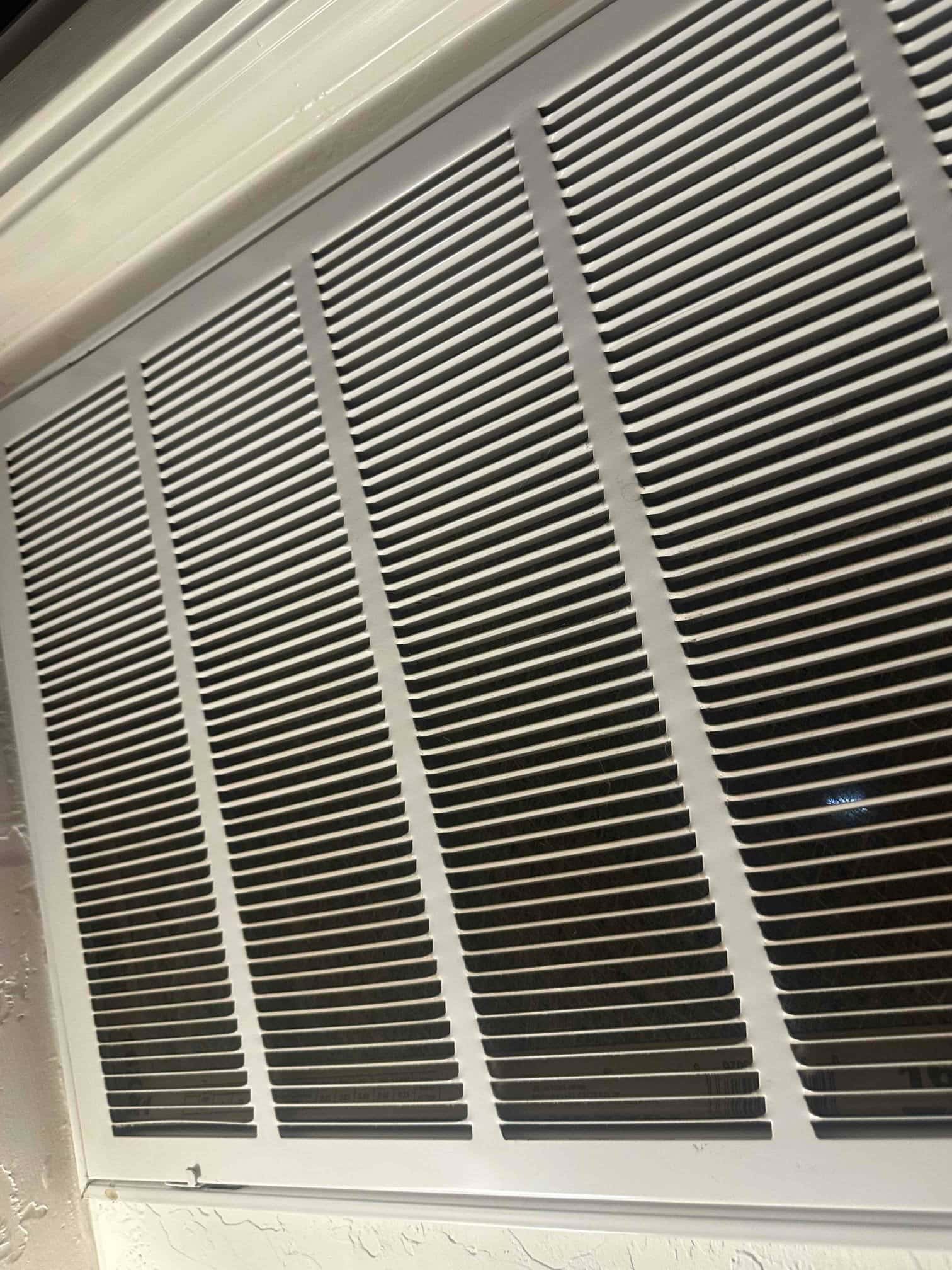 Large return air grille on an indoor air handler, showing clean louvers and surrounding trim ready for service.