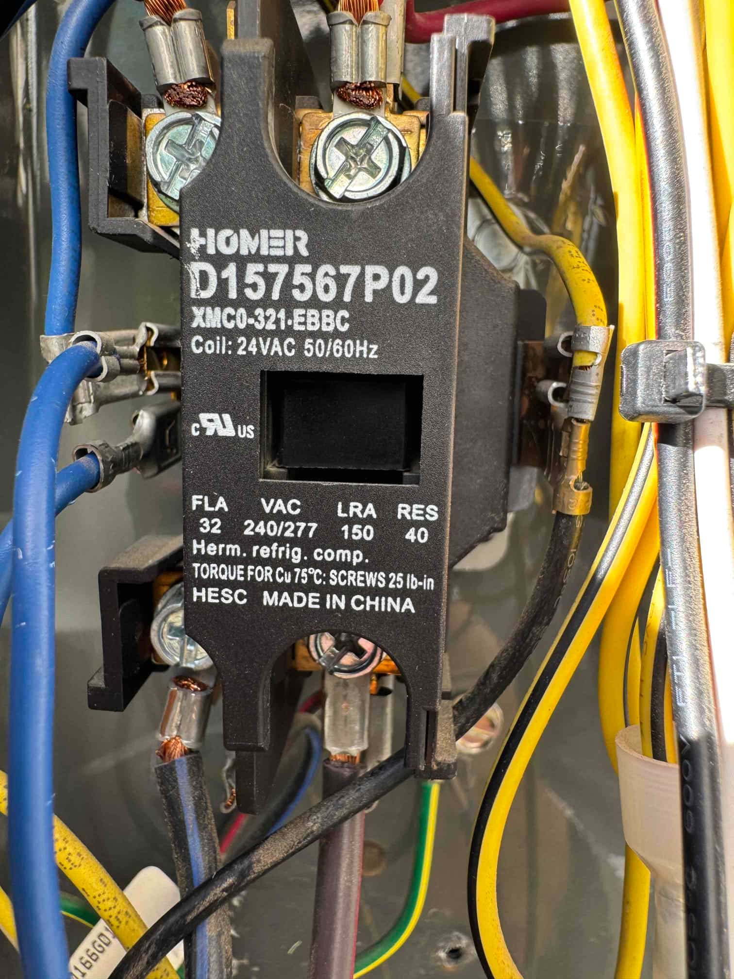 Close-up of an HVAC contactor installed with connected wires, showing clean terminals and printed specifications on the component body.