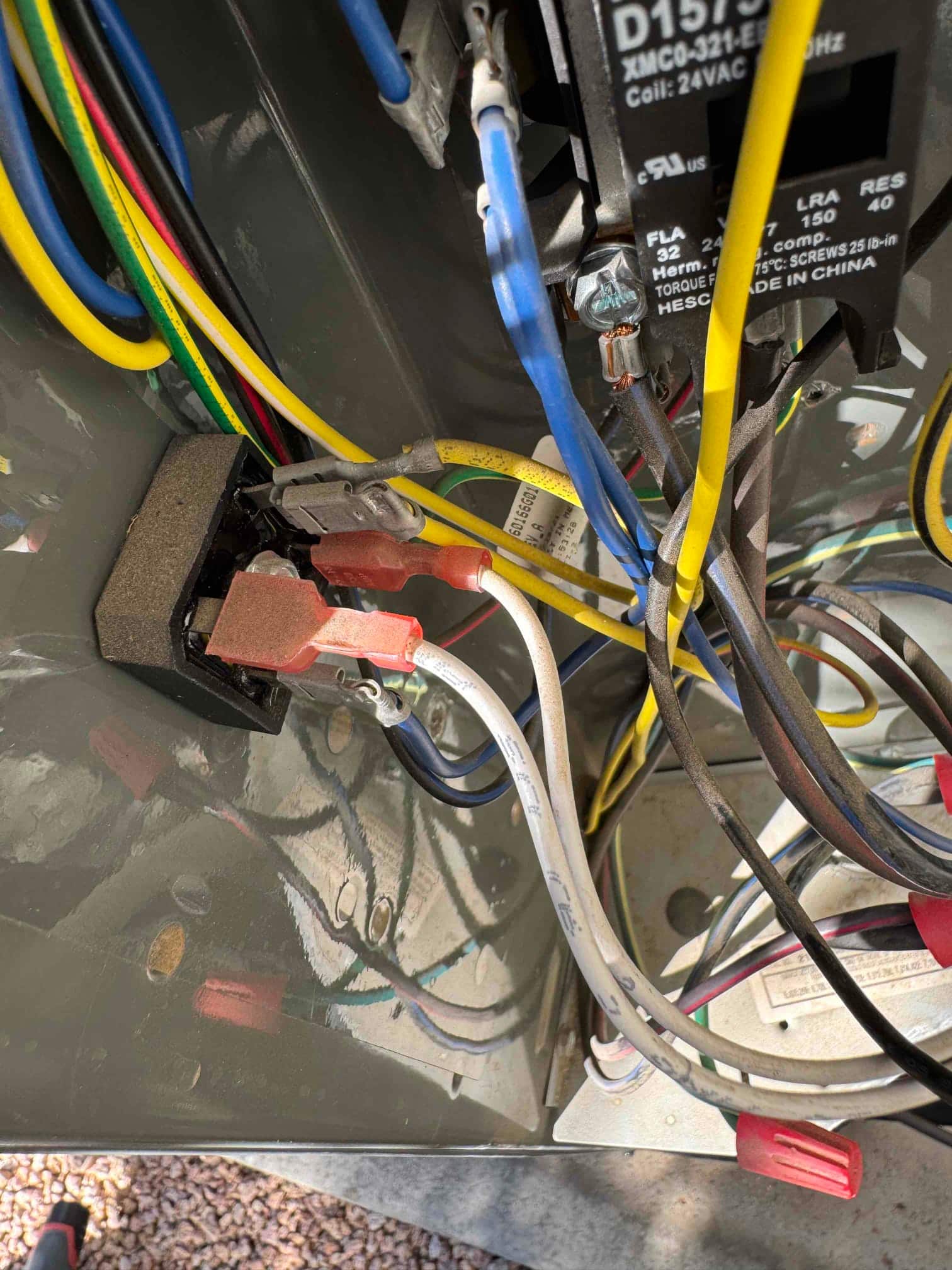 Condenser control compartment showing contactor, connected wires with wire nuts, and crimped spade terminals on control components.