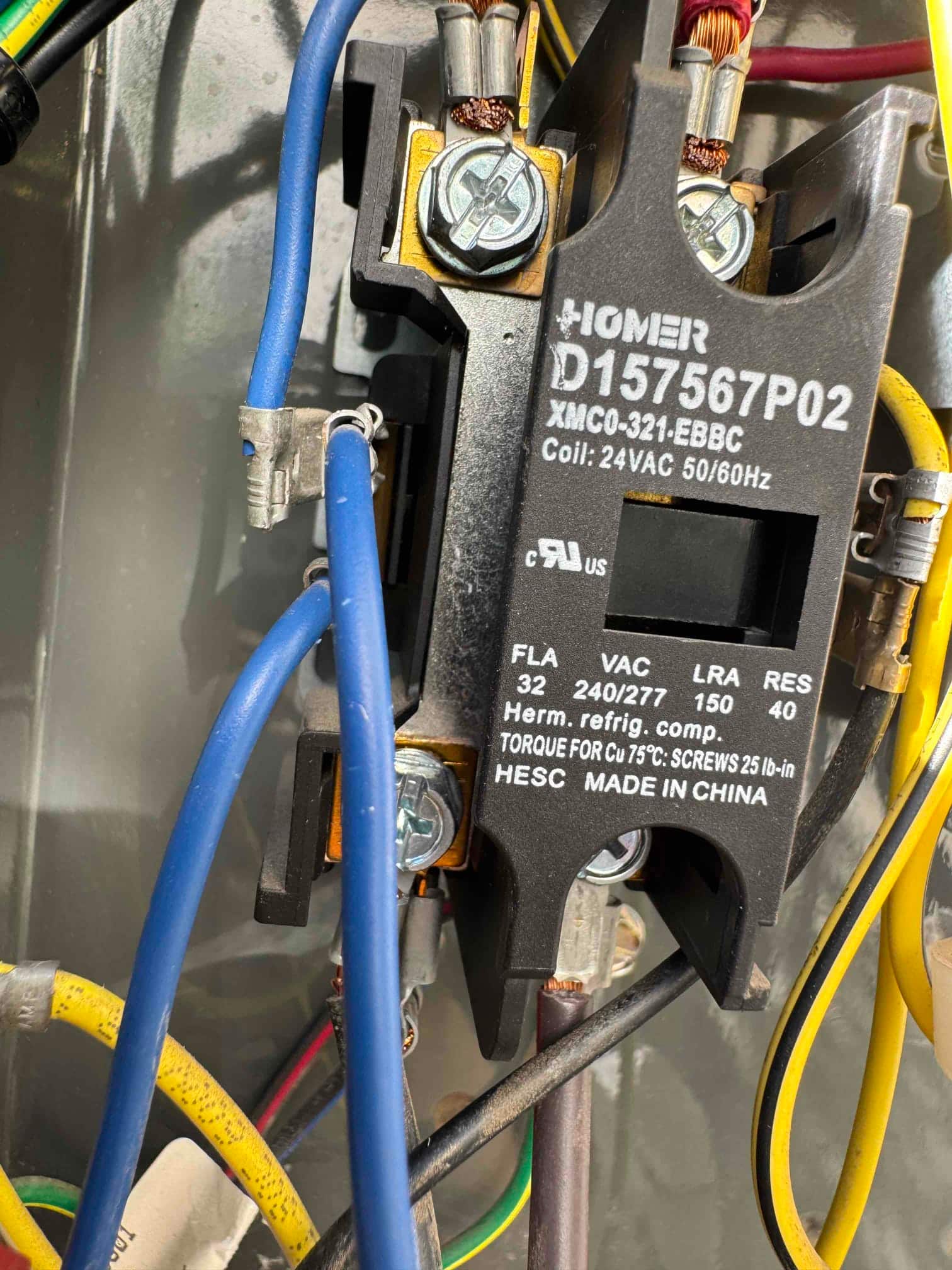 Contactor inside an air conditioning condenser control compartment, showing coil rated 24 VAC 50/60 Hz and wired line/load terminals.