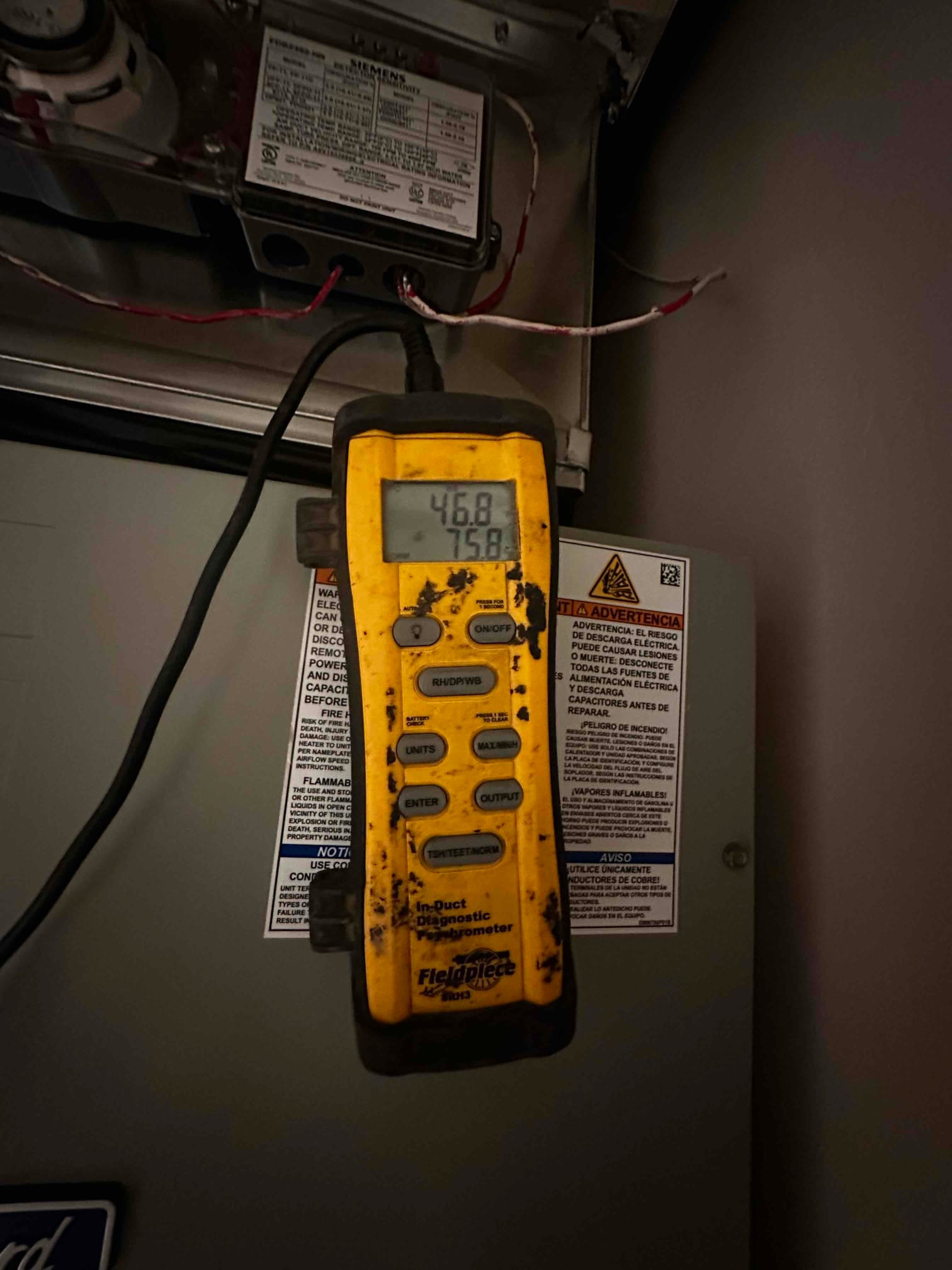 Digital in-duct thermometer displays 46.8°F supply air temperature with 75.8°F secondary reading during air-side checkout.