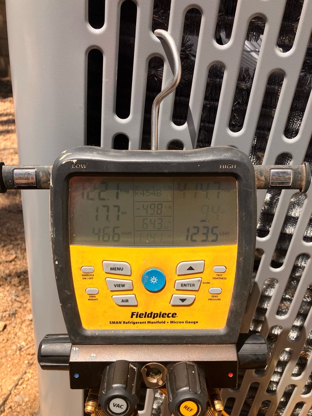 Digital manifold connected at the outdoor unit shows operating pressures with R-454B selected during system commissioning.