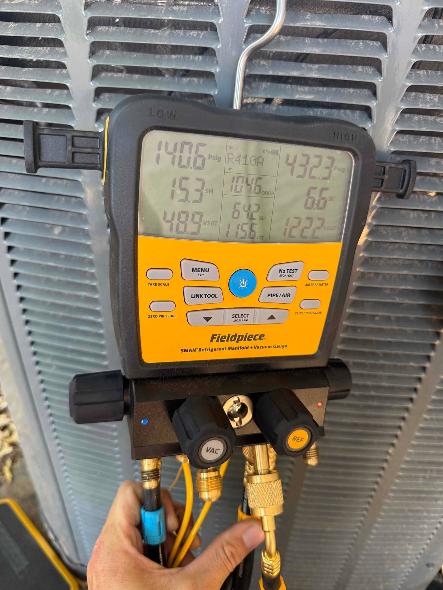 Digital manifold gauge connected to an outdoor condenser shows 140.6 psi on the low side and 432.3 psi on the high side.