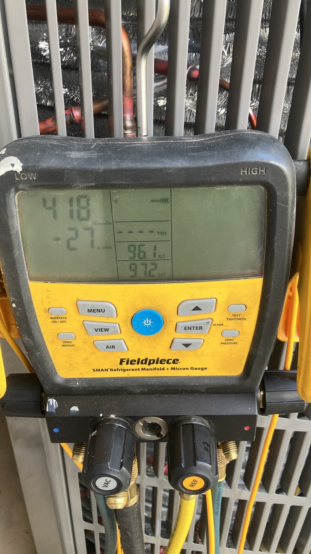 Digital manifold gauges display 418 PSI on both sides during a nitrogen pressure test of the installed system.