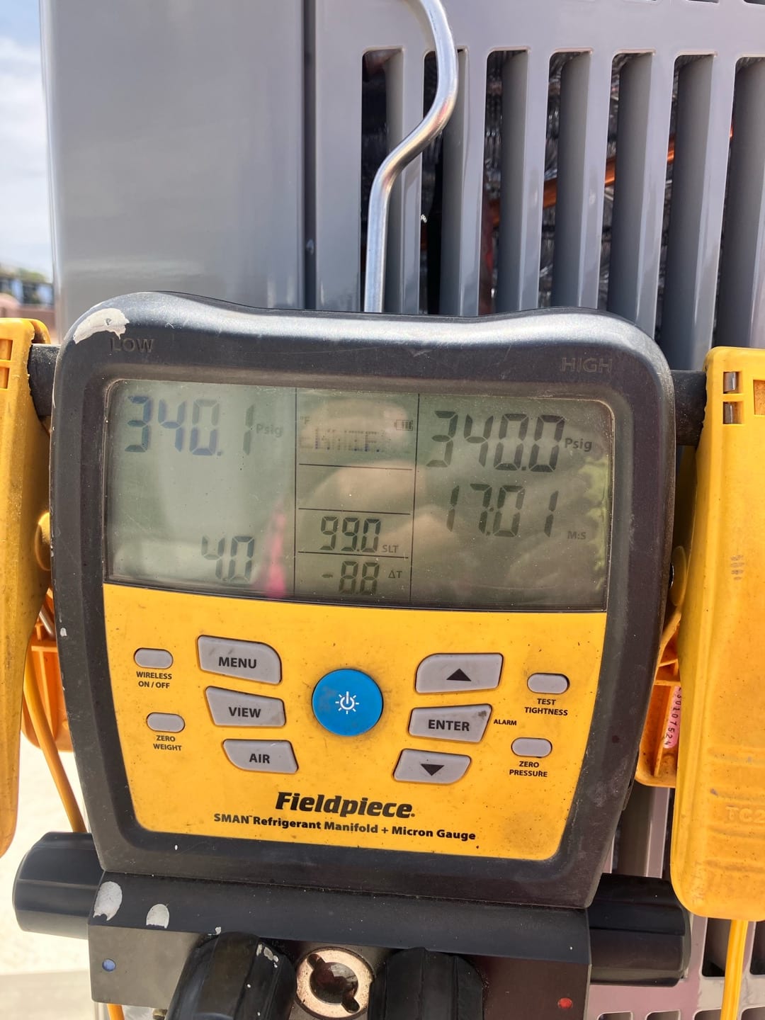 Digital manifold shows equal pressures near 340 PSI on both sides during a nitrogen pressure test at the outdoor unit.