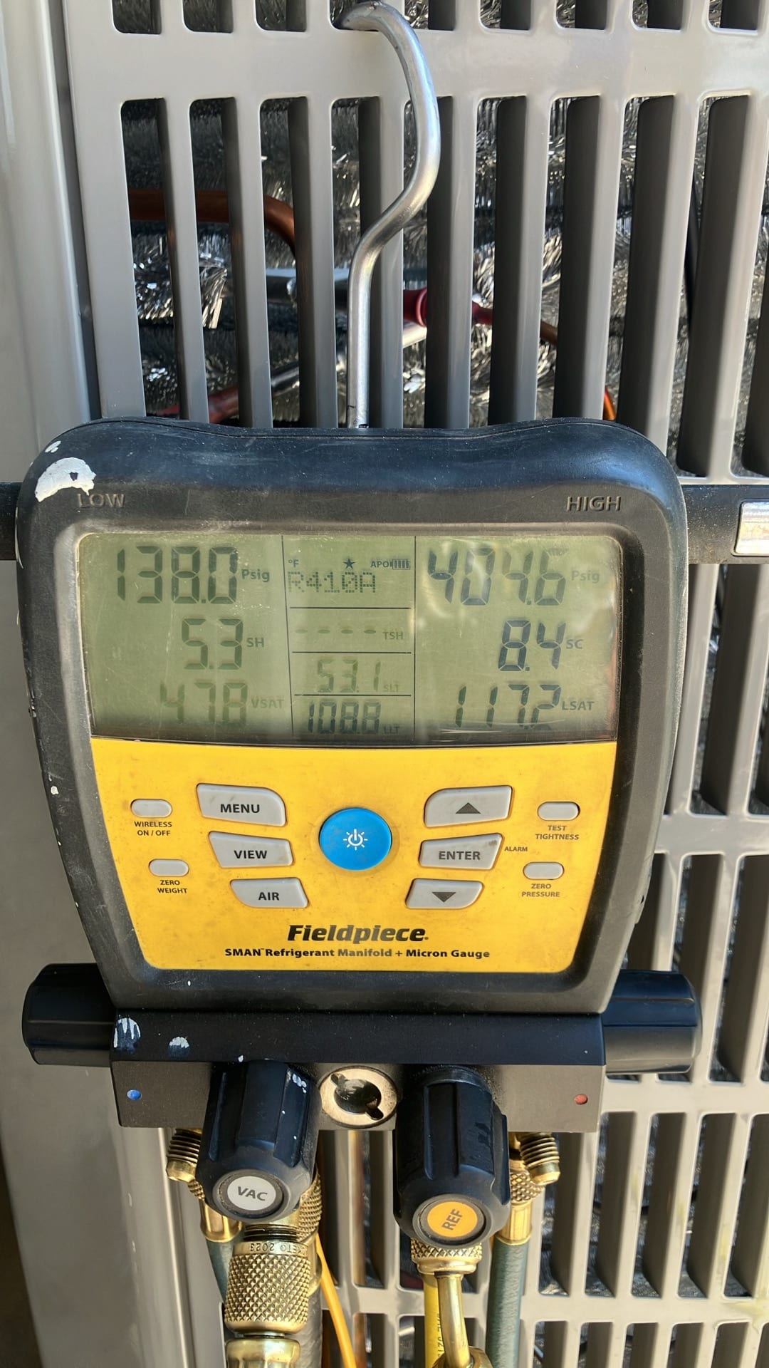 Digital manifold shows system operating pressures with superheat and subcooling while commissioning the outdoor unit.