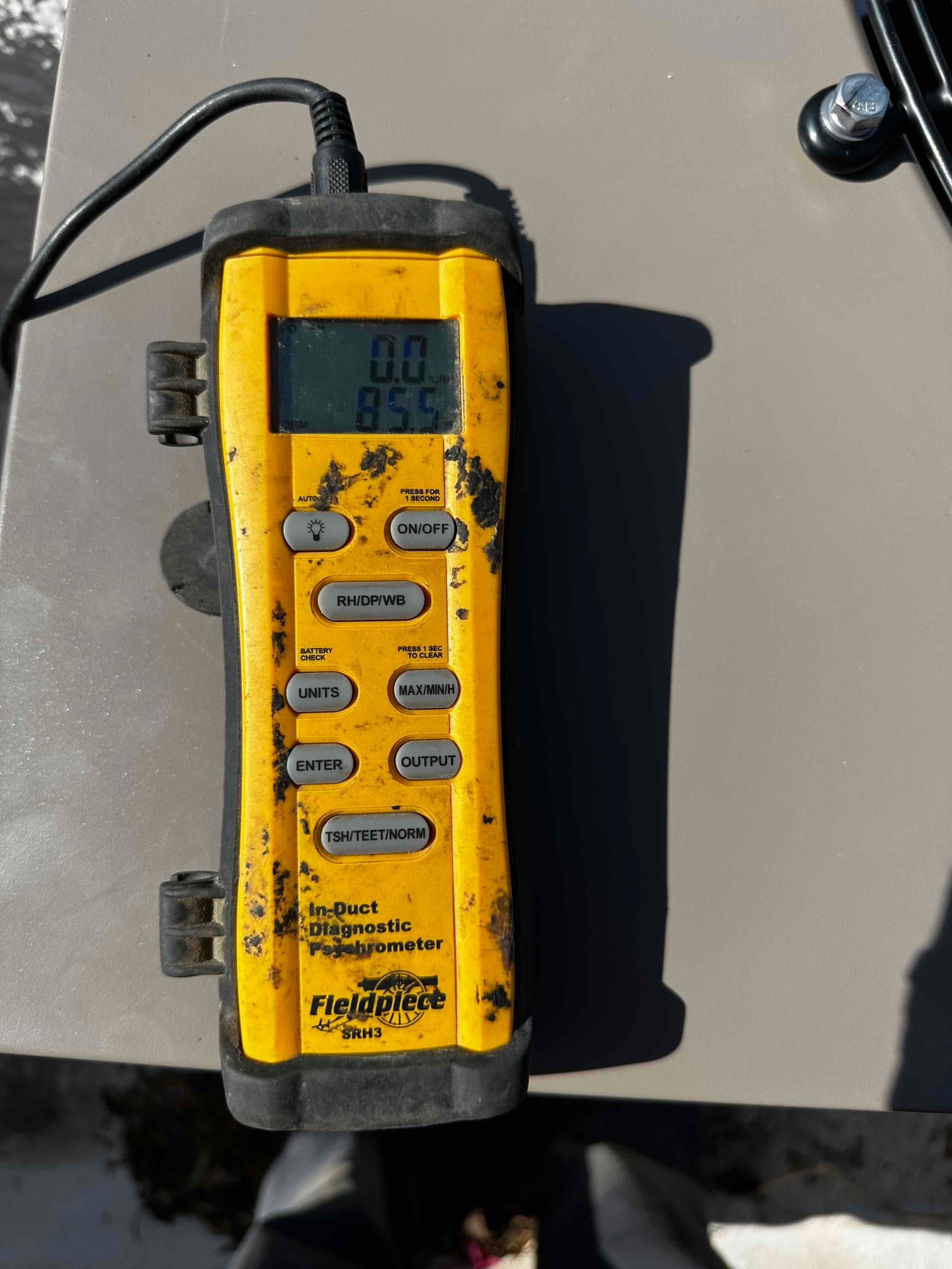 Digital thermometer/hygrometer on the outdoor unit shows an air temperature reading of 85°F during commissioning checks.