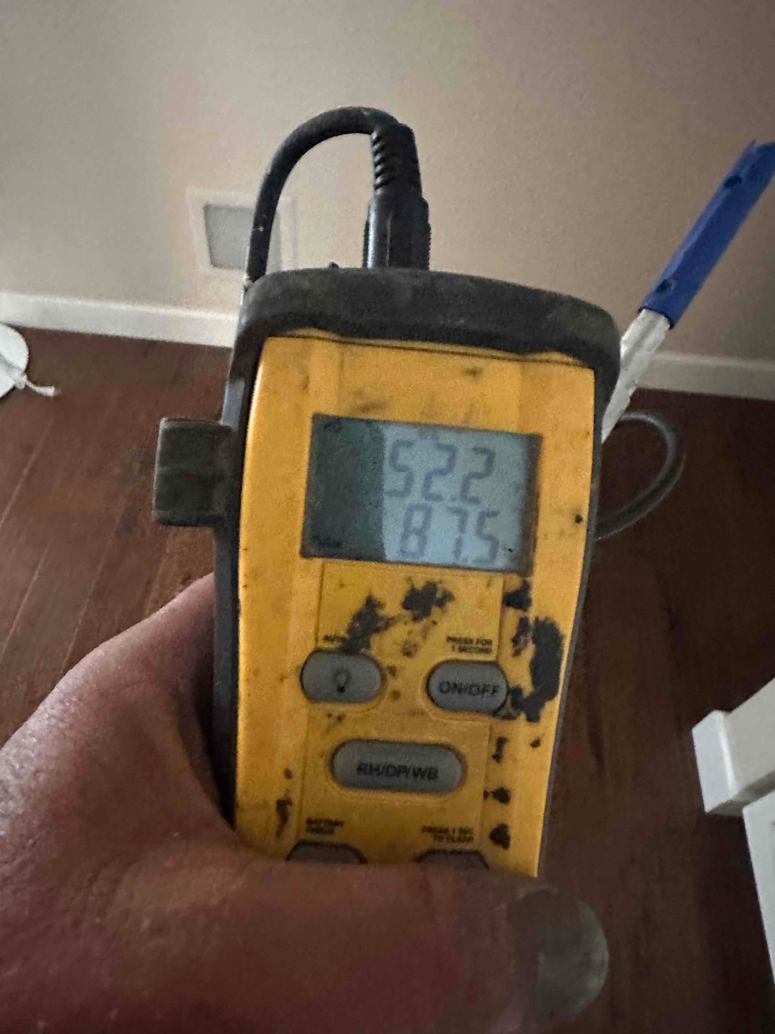 Digital thermometer shows 52.2 degrees on the top display and 87.5 degrees on the lower display during air temperature checks.