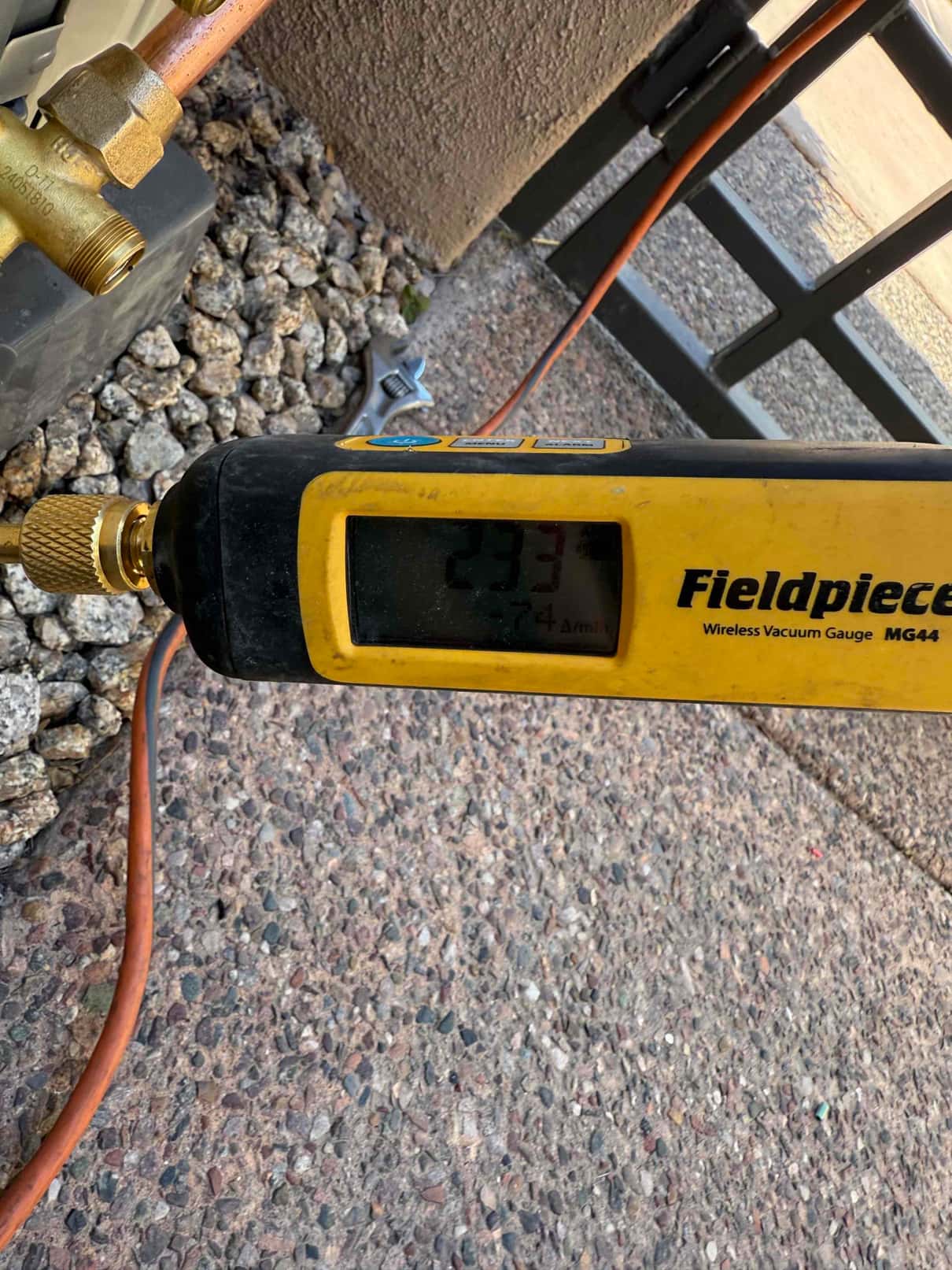 Micron gauge connected at the service port reads 233 microns, confirming a deep vacuum during system evacuation.