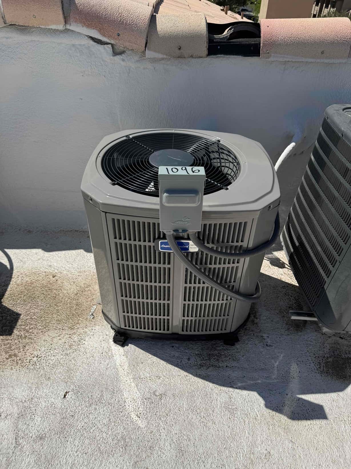 New outdoor condenser set on risers with insulated refrigerant lines routed to the unit on a rooftop installation.