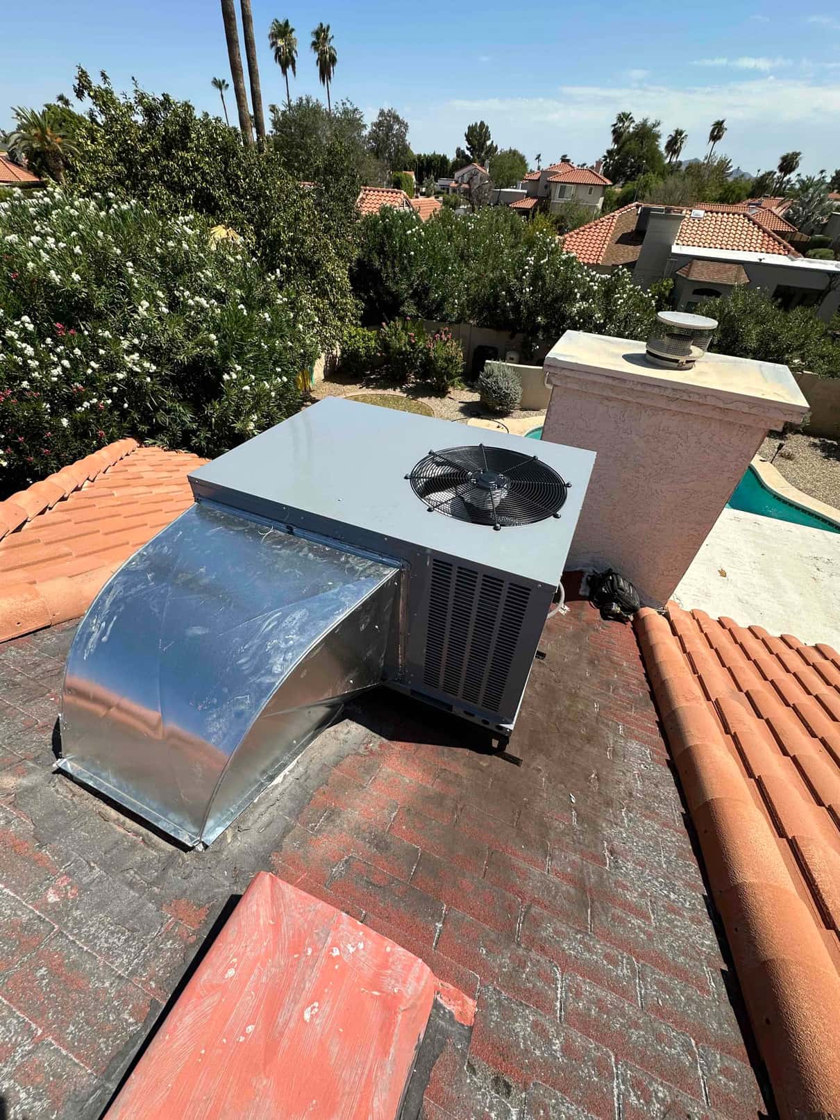 New rooftop package unit set on the roof with sealed sheet-metal curb and supply duct transition connected.