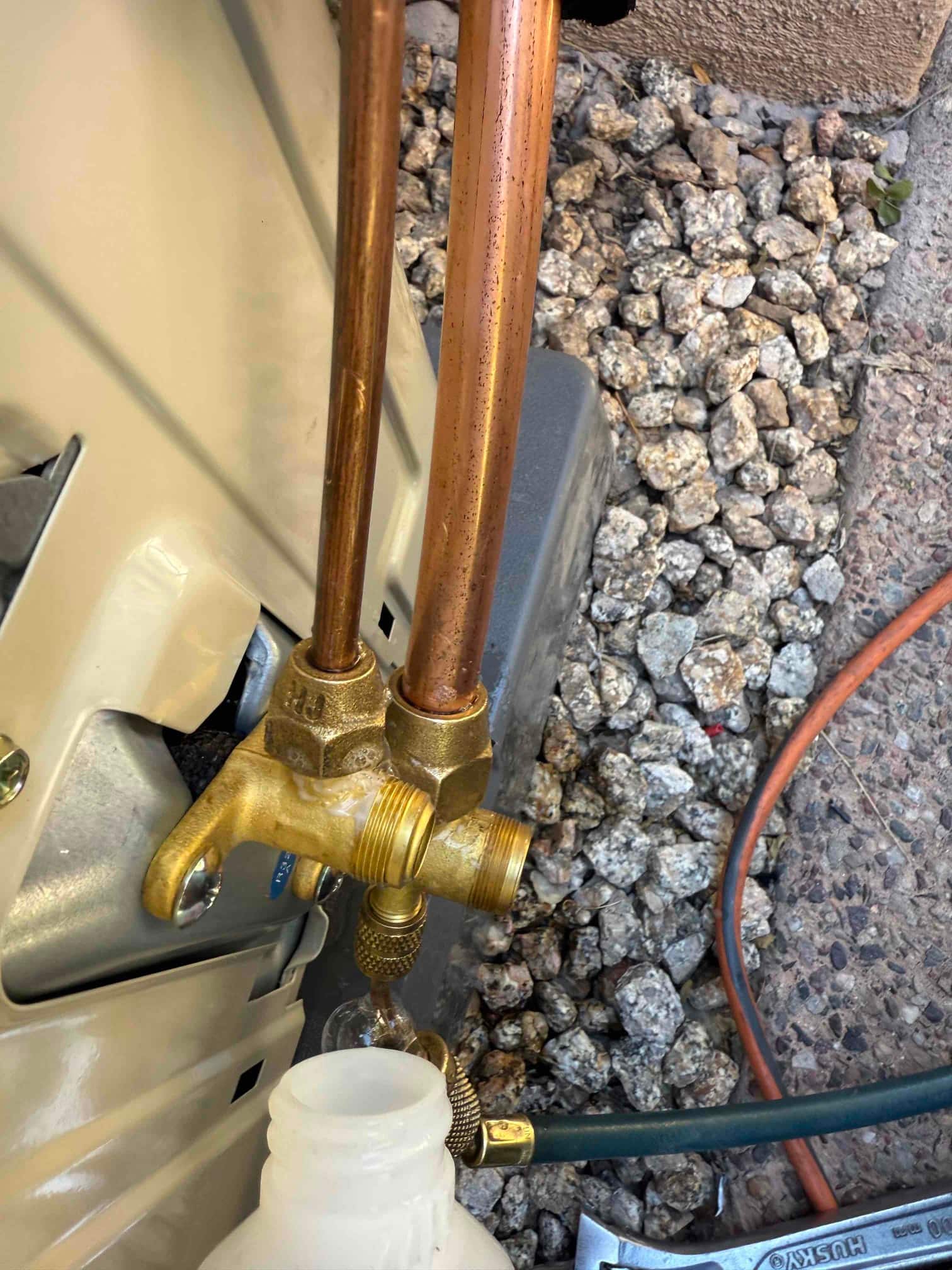 Refrigerant service valves on the outdoor mini-split with copper line set and hose connected during installation.