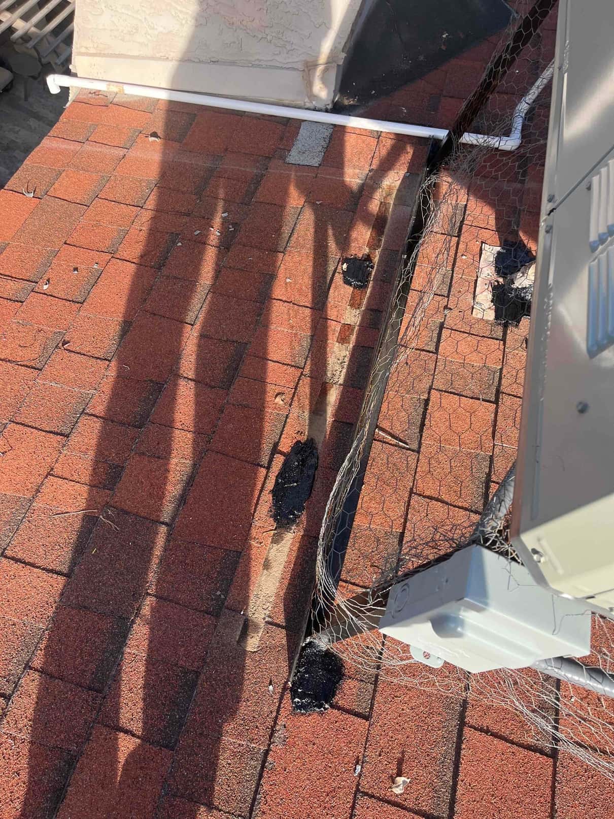 Rooftop heat pump installation details showing sealed roof penetrations, protective wire mesh, and electrical disconnect mounted beside the unit.