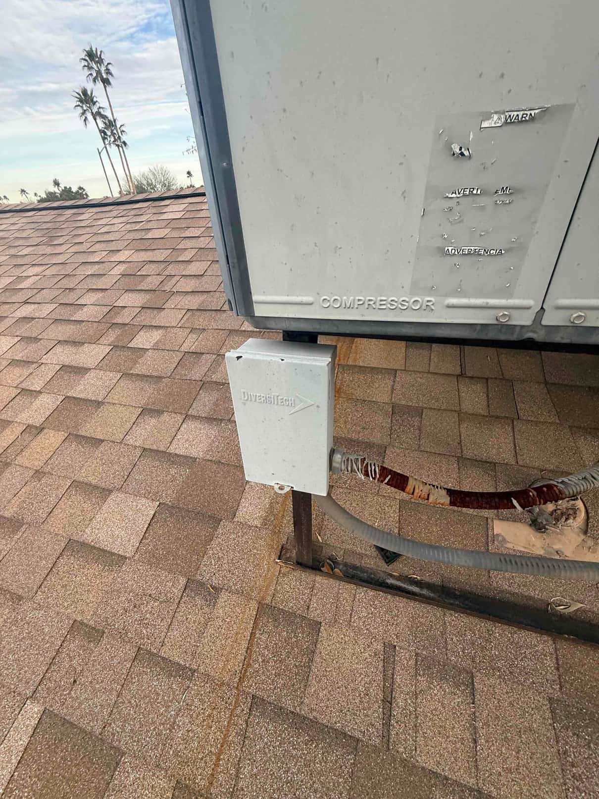 Rooftop HVAC unit with exterior disconnect box and armored electrical conduit entering the cabinet for service power.