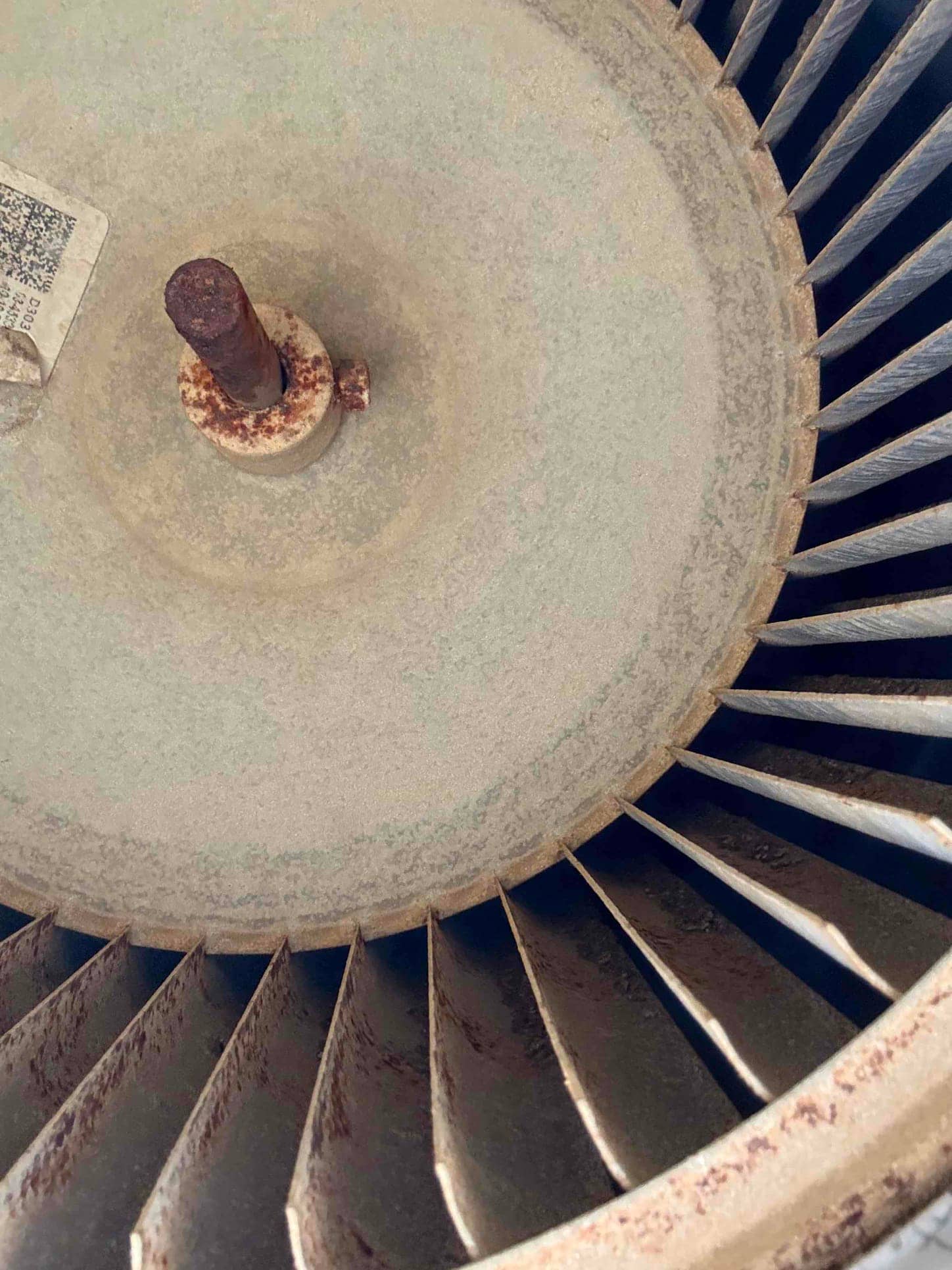 Rusted condenser fan blade assembly and motor shaft showing corrosion on the hub and blade surfaces.