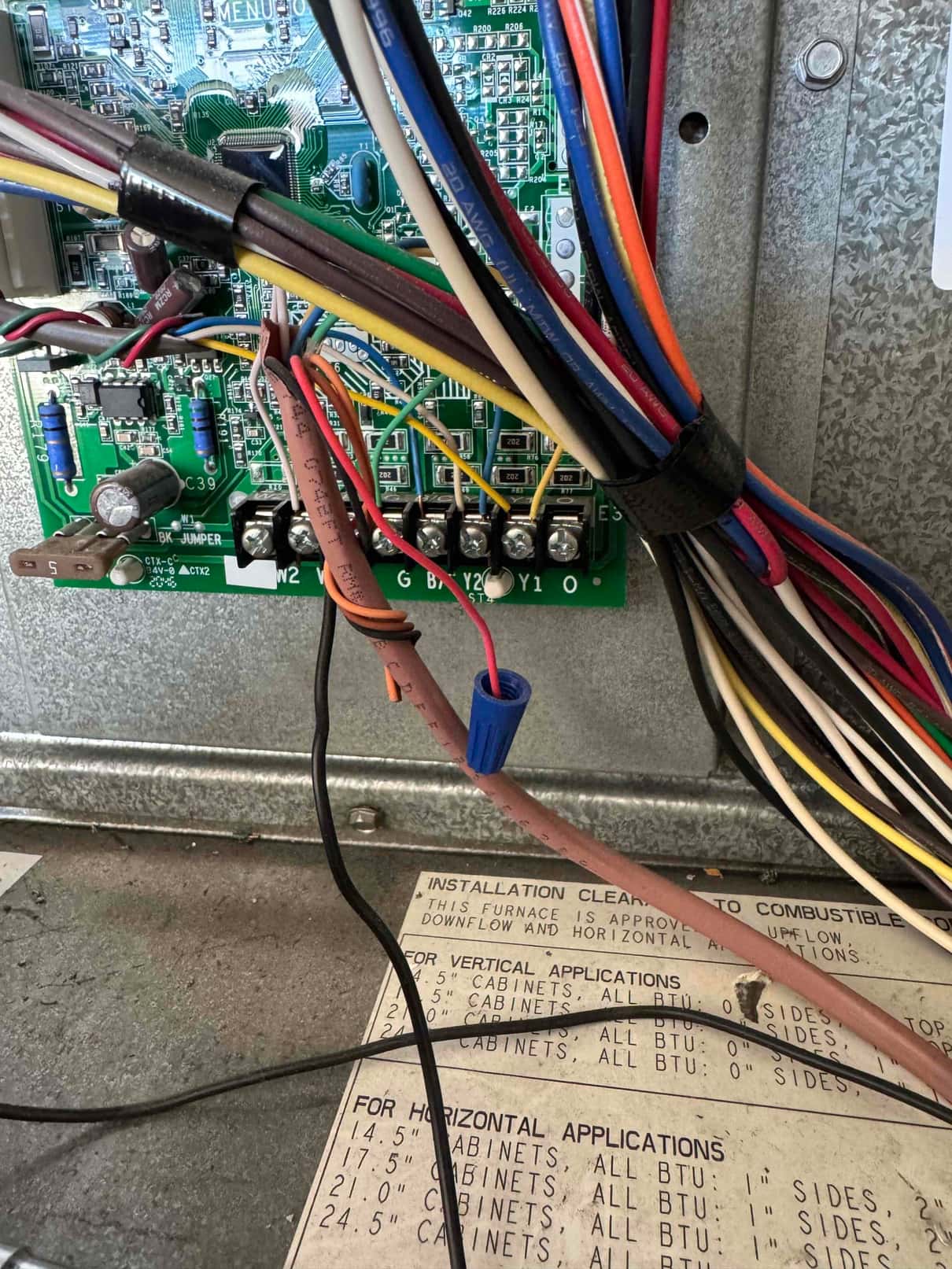 Thermostat control wiring connected to a furnace control board with labeled terminals R, C, W1, W2, G, B/K, Y1, and O.