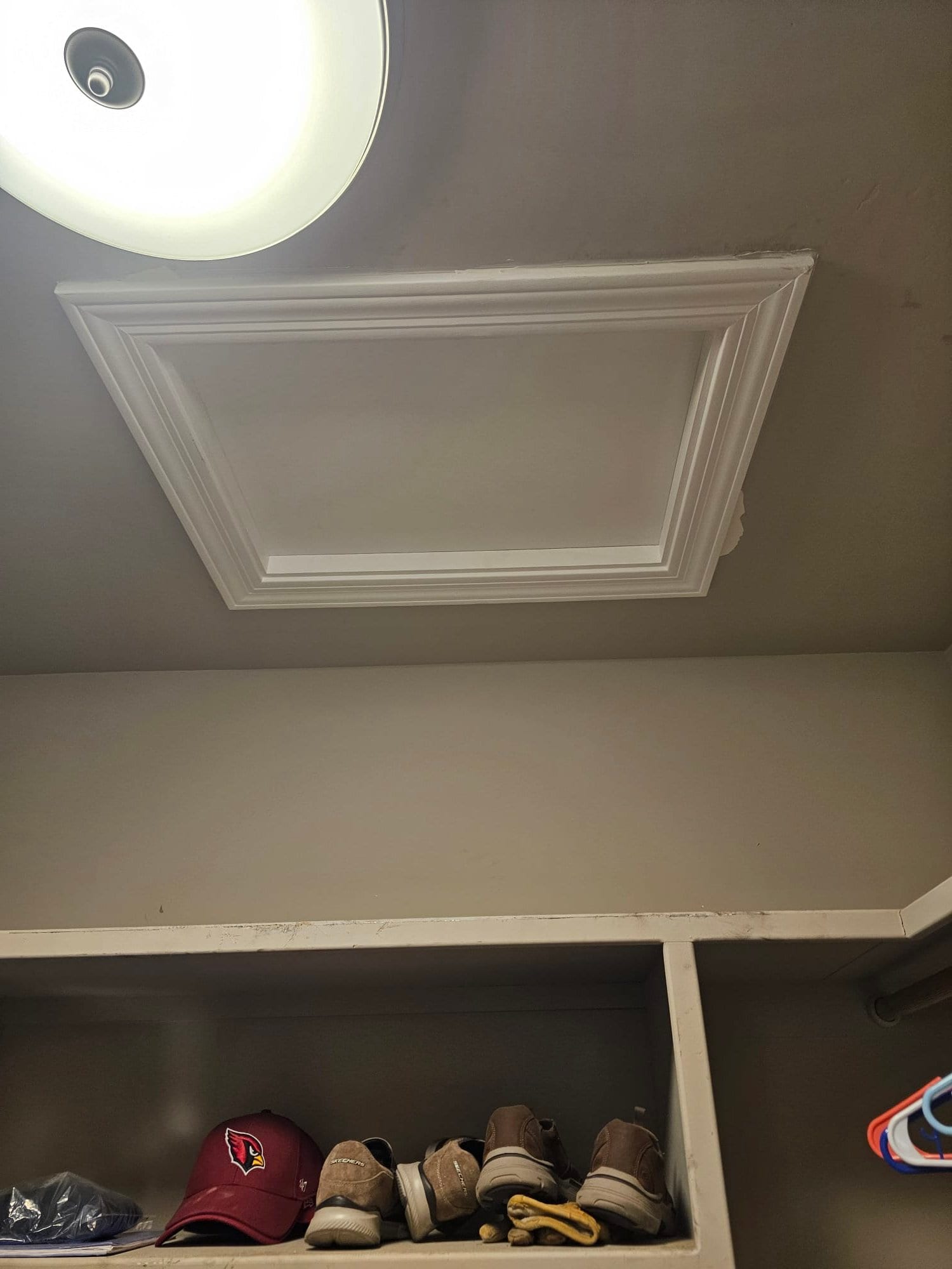 Ceiling attic access panel in a closet, providing entry to the attic space for HVAC installation and service.
