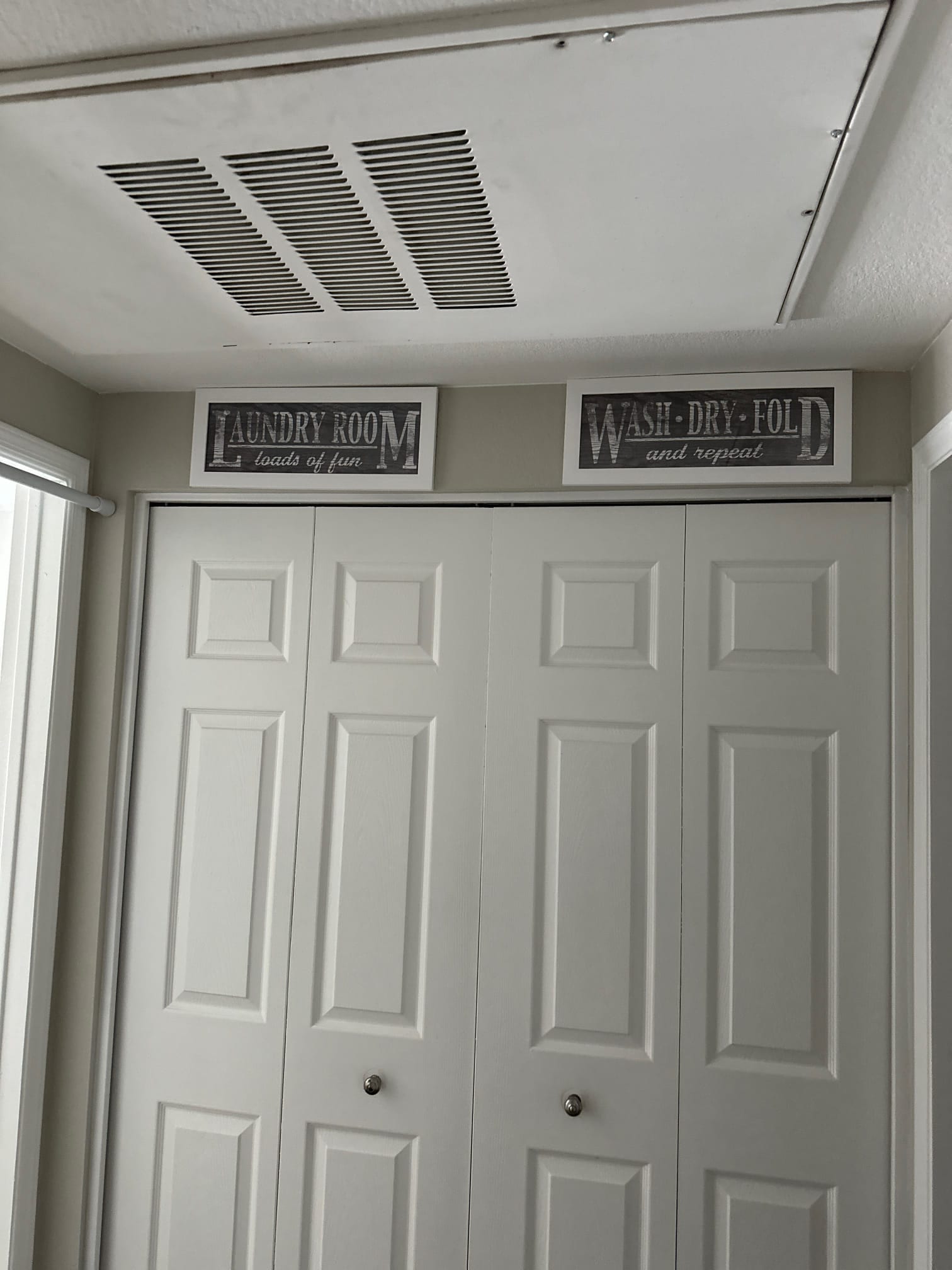 Ceiling return air grille installed above laundry closet, showing finished trim and secure mounting in the hallway area.