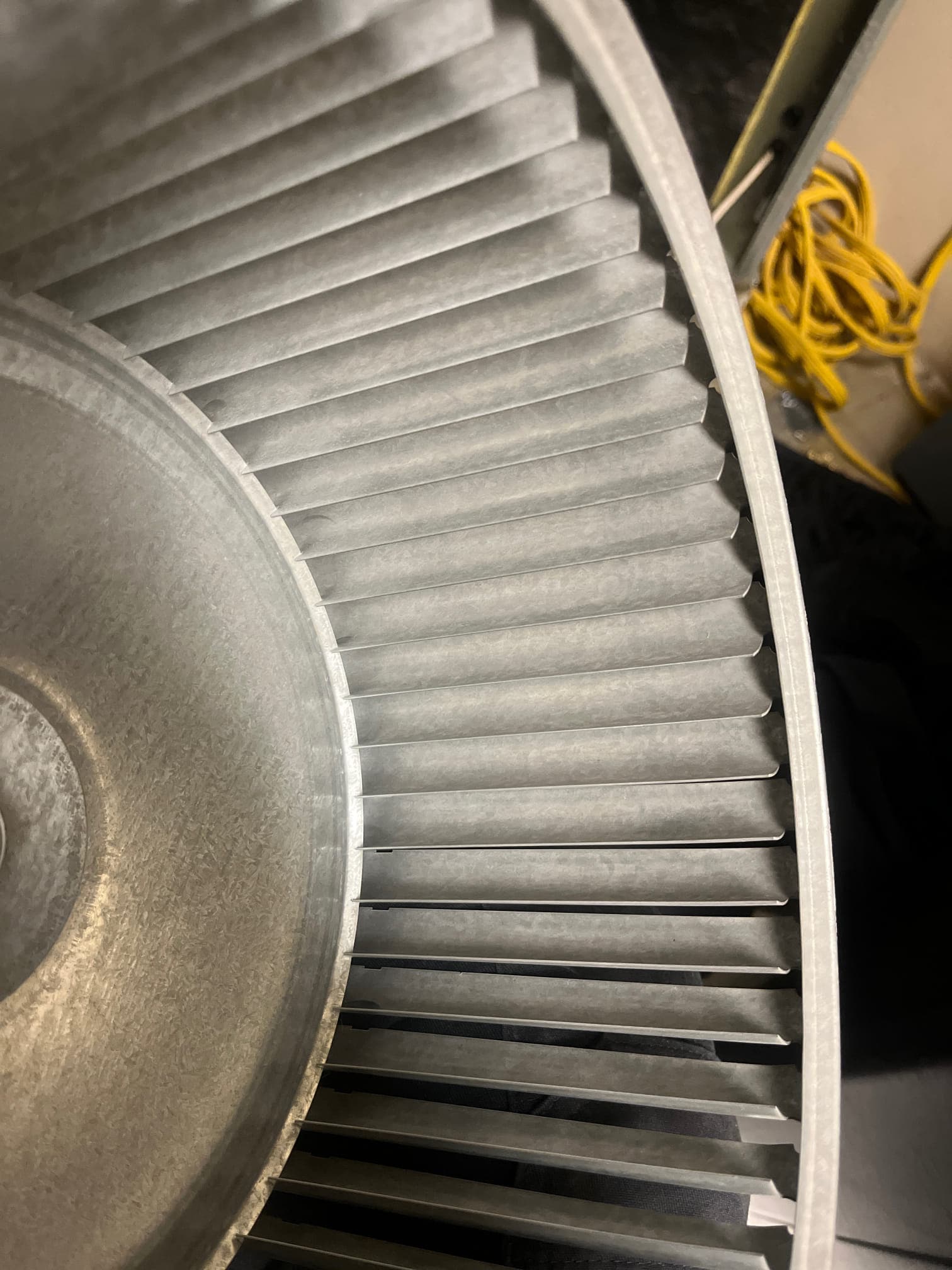 Close-up of a clean blower wheel with straight fins, showing metal surfaces free of dust and debris.